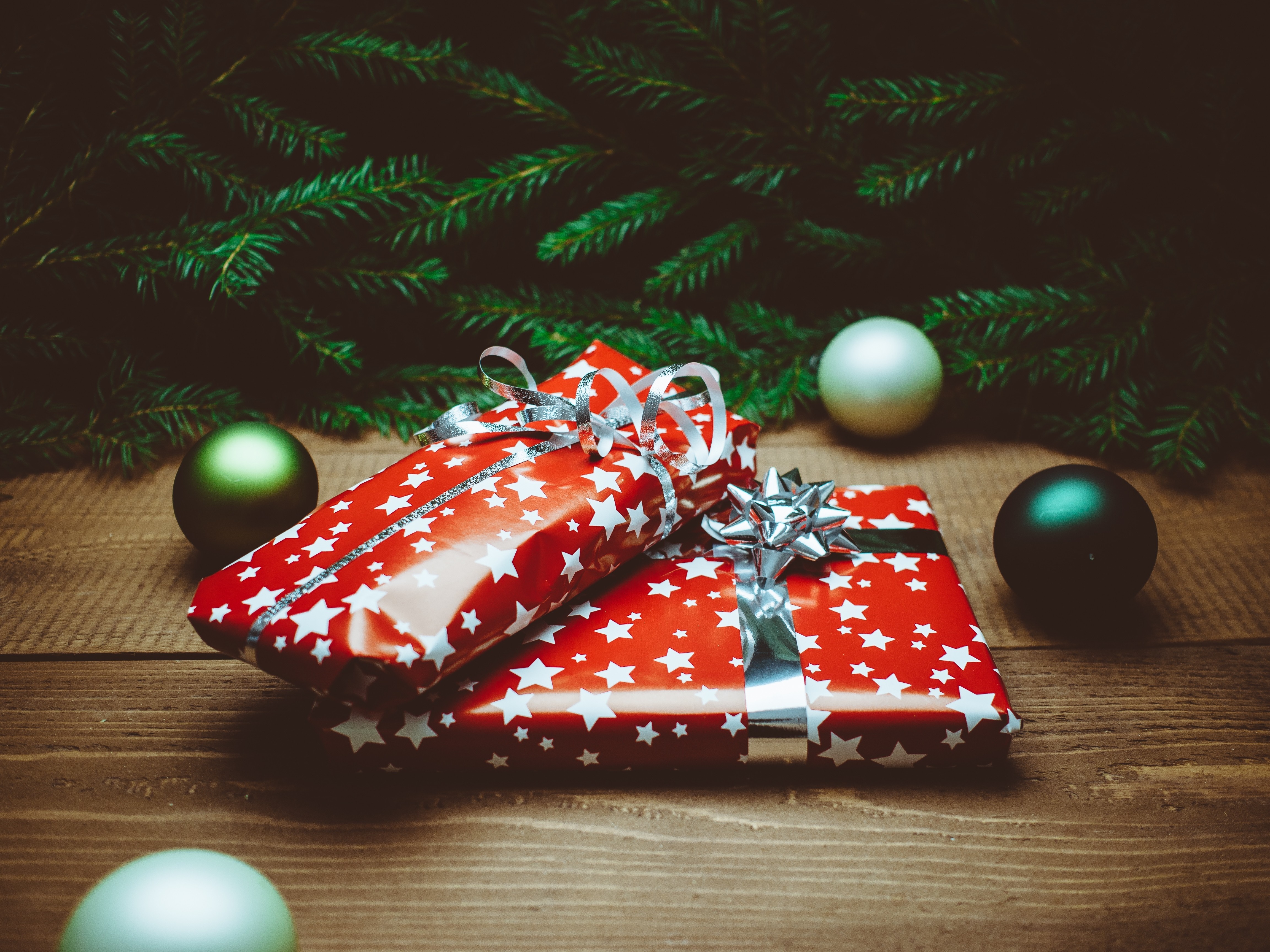 Christmas presents and ornaments on a wooden table HD Wallpaper