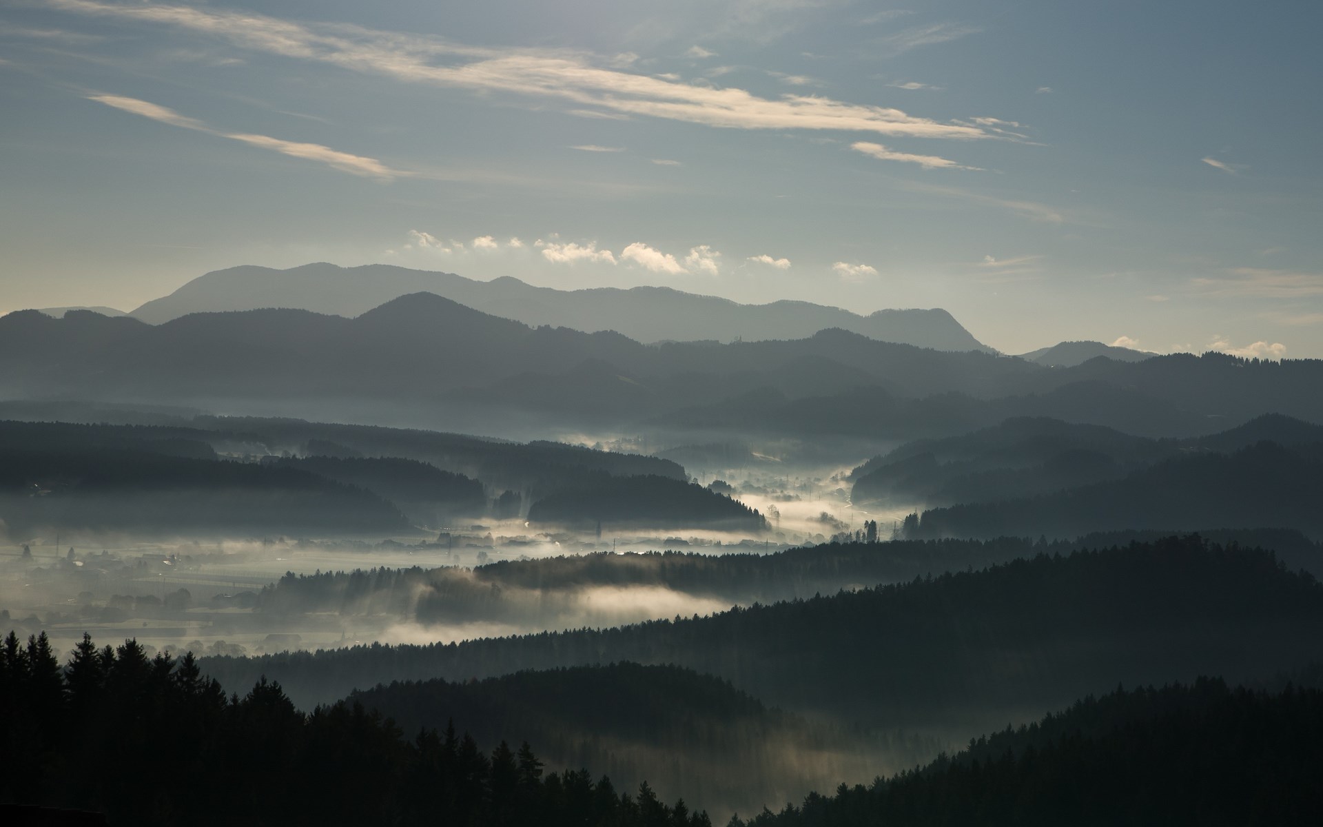 Misty mountain range at sunrise with fog in valleys HD Wallpaper
