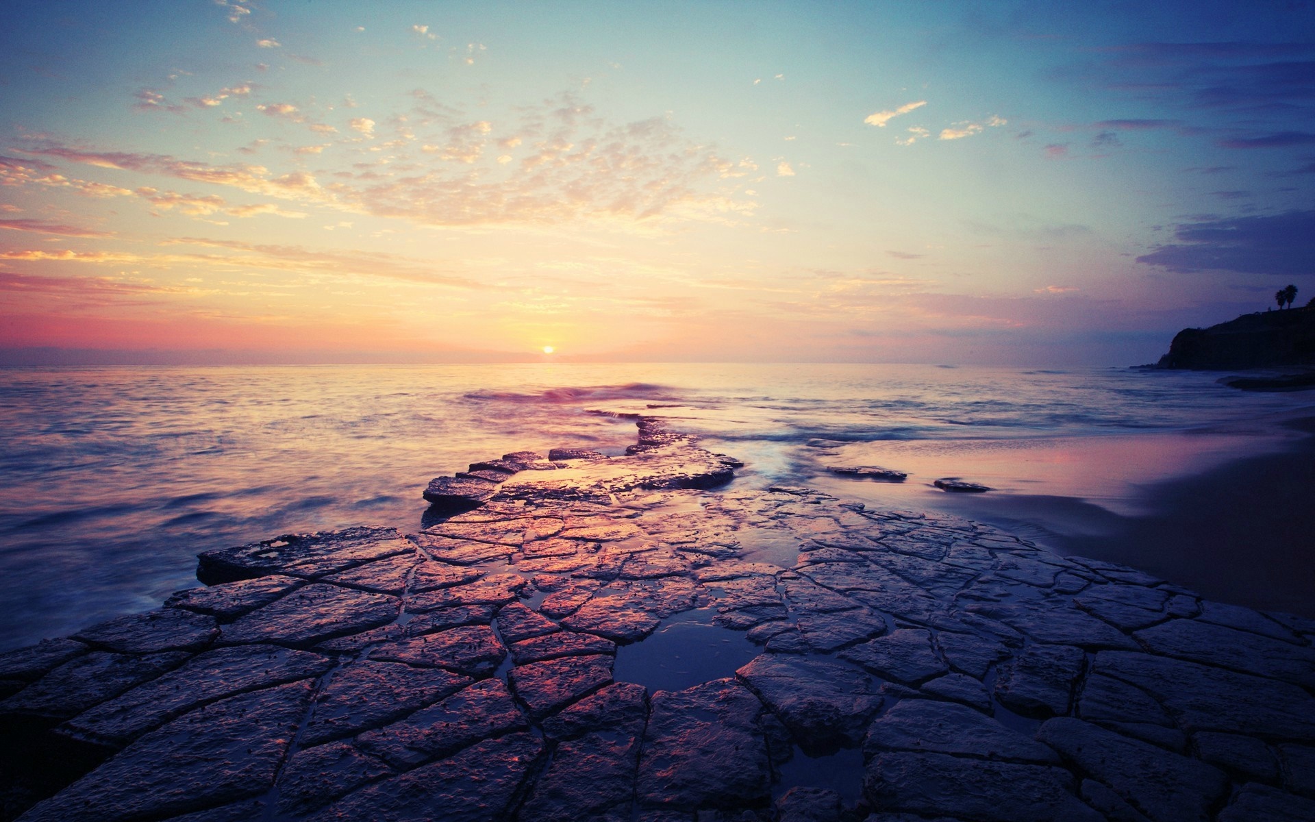 Sunset over the ocean with rocky shore HD Wallpaper