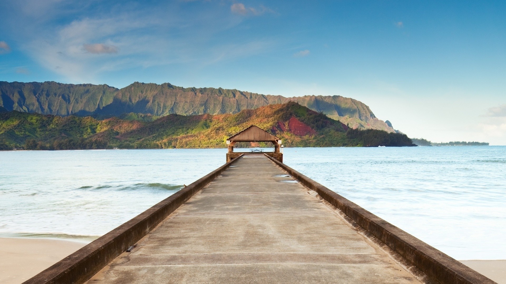 Pier with a covered shelter leading to mountains over the sea HD Wallpaper