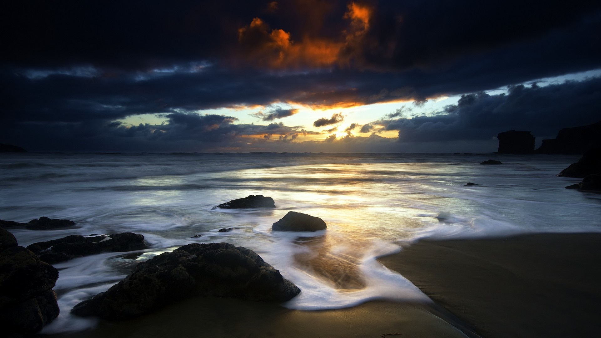 Sunset over the sea with rocks on the shore HD Wallpaper