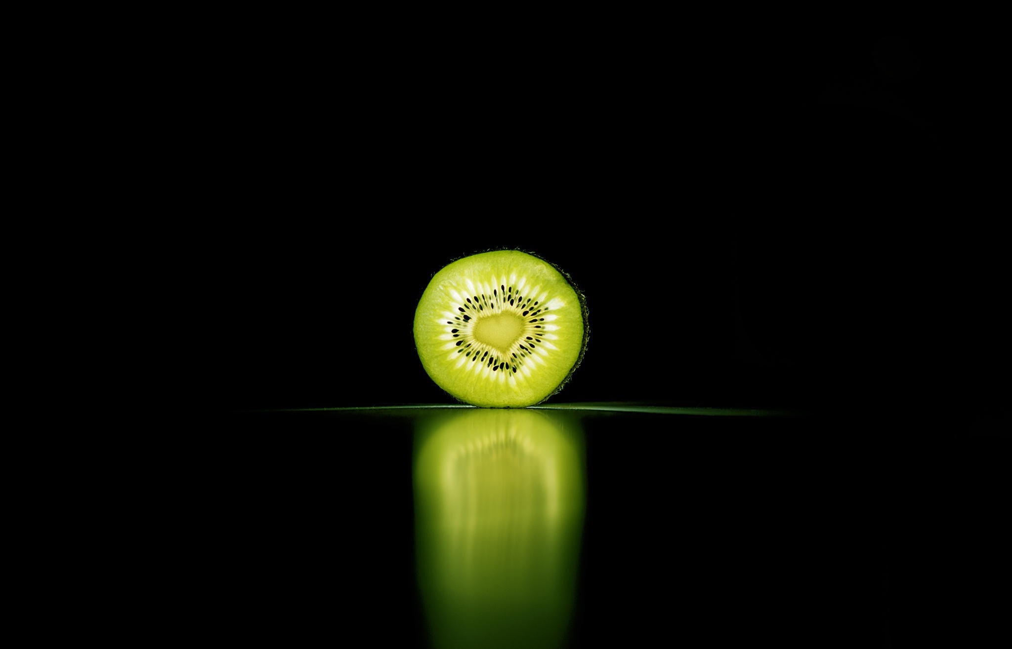 Close up of a sliced kiwi fruit on a dark background HD Wallpaper