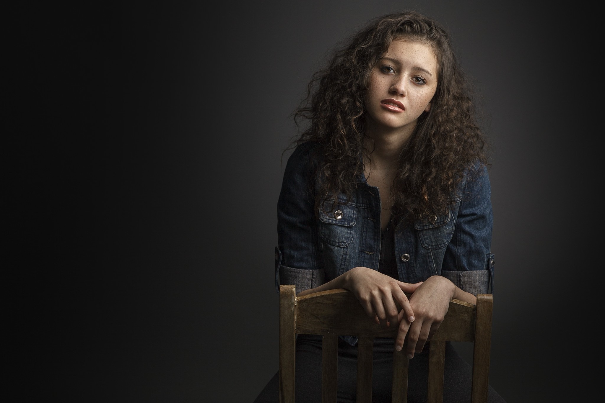 Woman with curly hair sitting on a chair HD Wallpaper