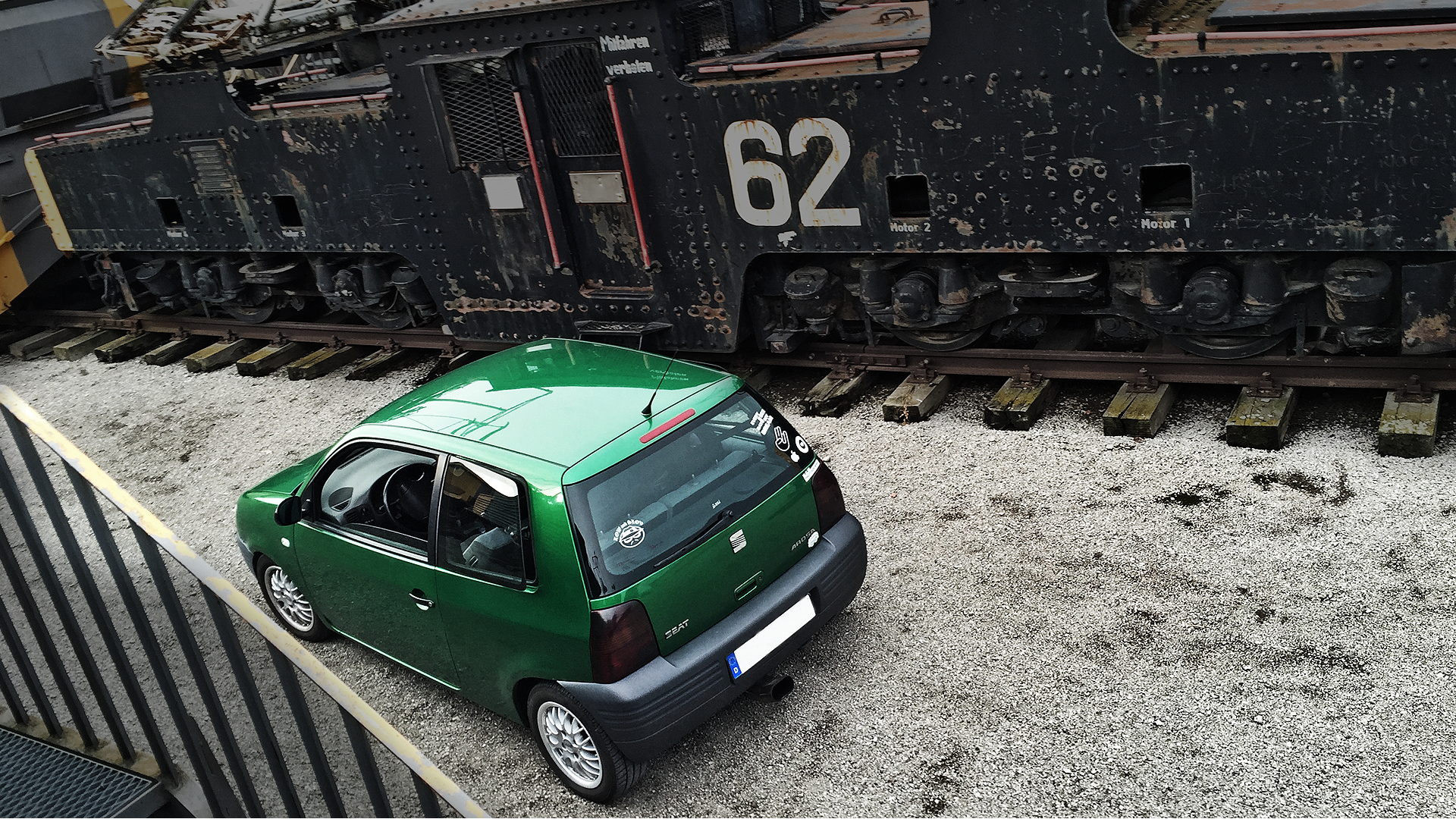 Green Seat Arosa parked next to a vintage train HD Wallpaper
