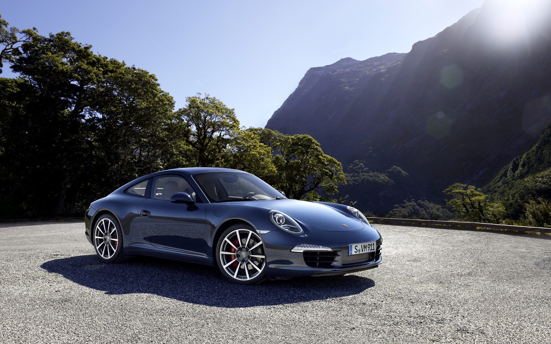 Blue Porsche 911 parked on gravel road with mountains HD Wallpaper