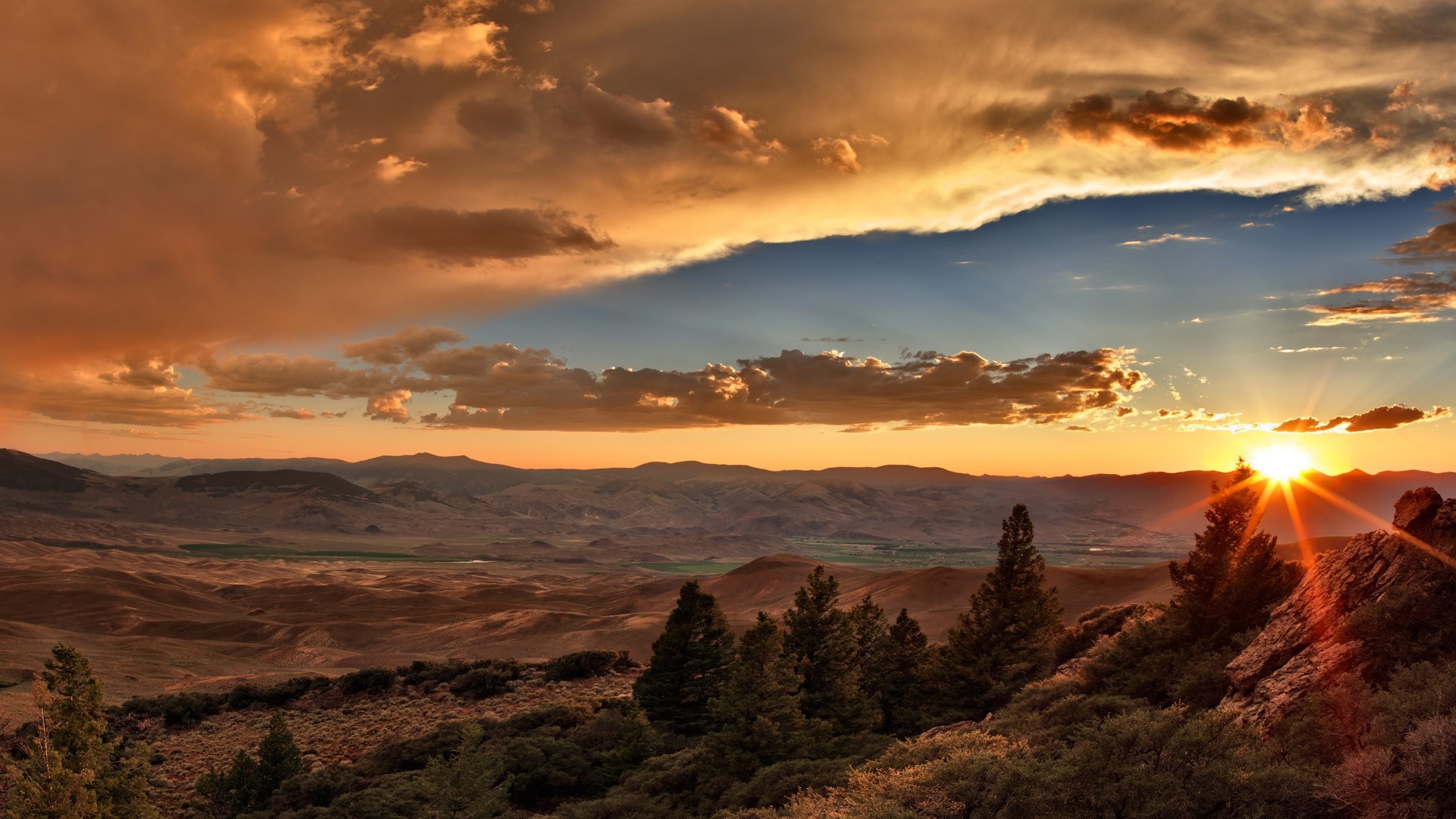 Sunset over mountainous landscape with dramatic clouds HD Wallpaper