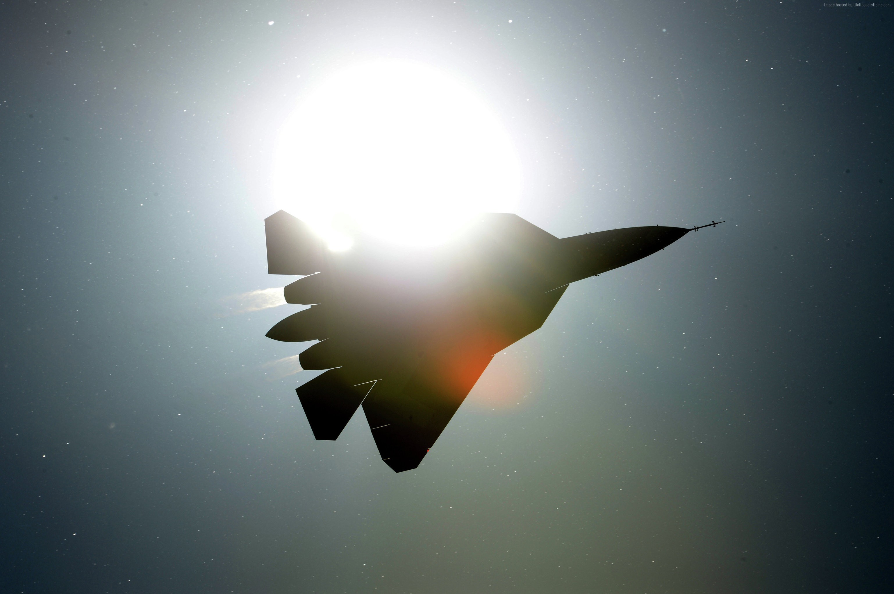 Sukhoi Su-57 fighter jet silhouetted against the sun HD Wallpaper
