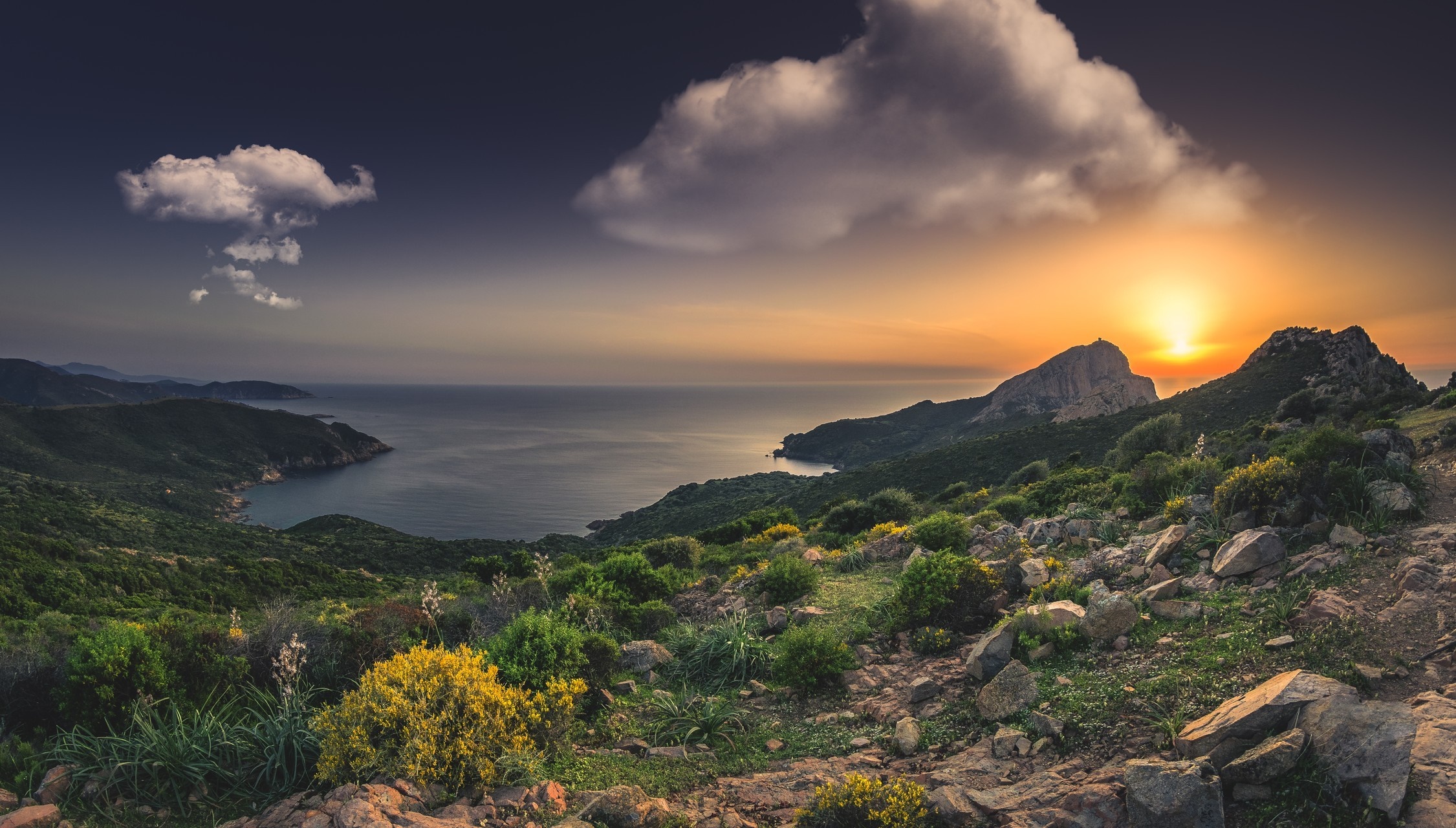 Sunset over a mountainous coastline with the sea HD Wallpaper