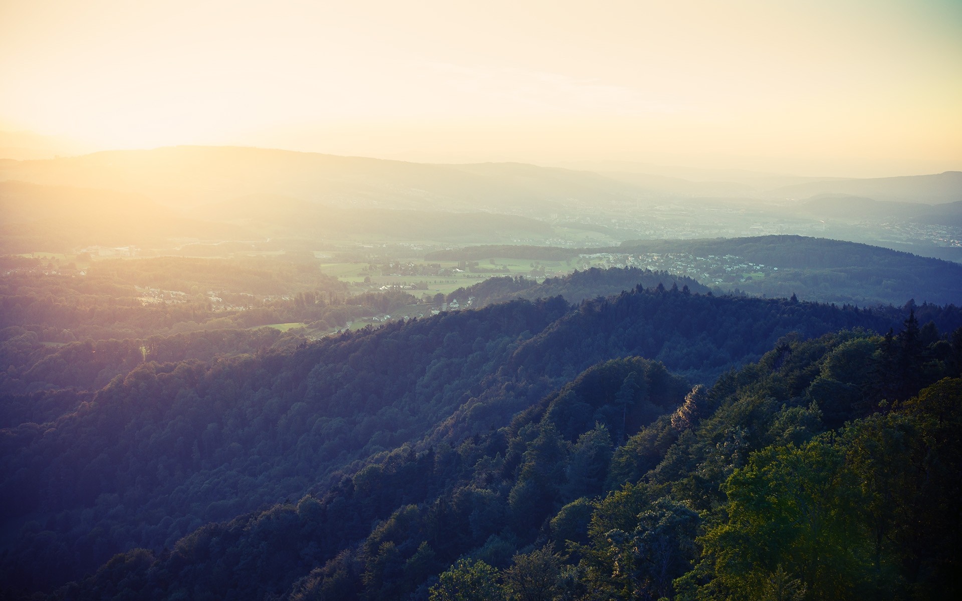 Sunlight over forested hills and valley at dawn HD Wallpaper