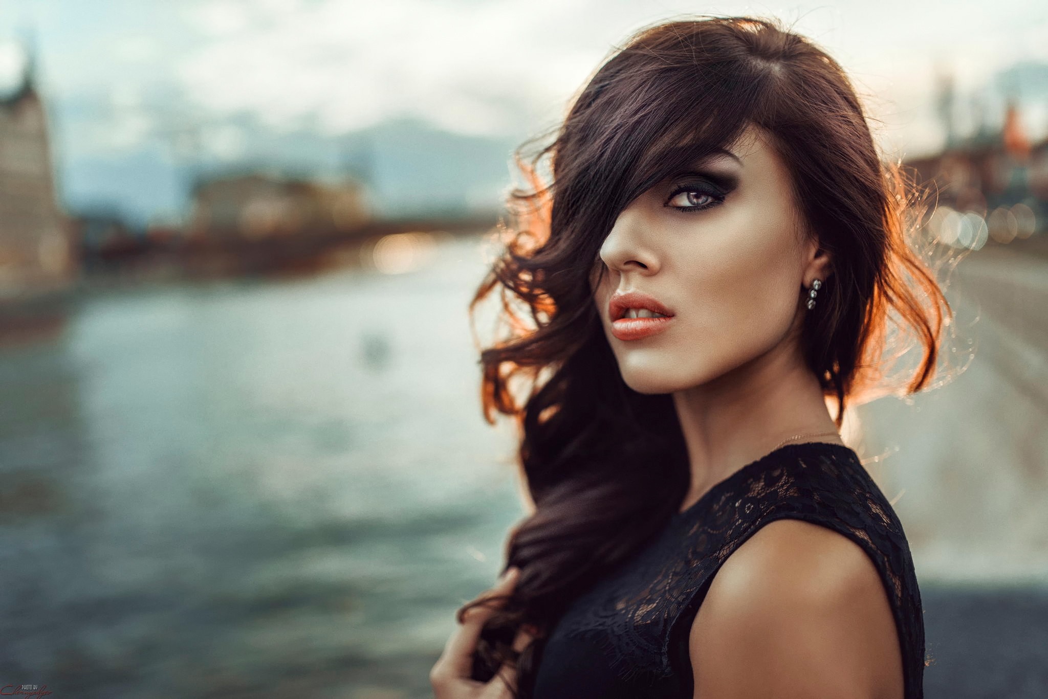 Woman with dark hair and makeup by the water HD Wallpaper