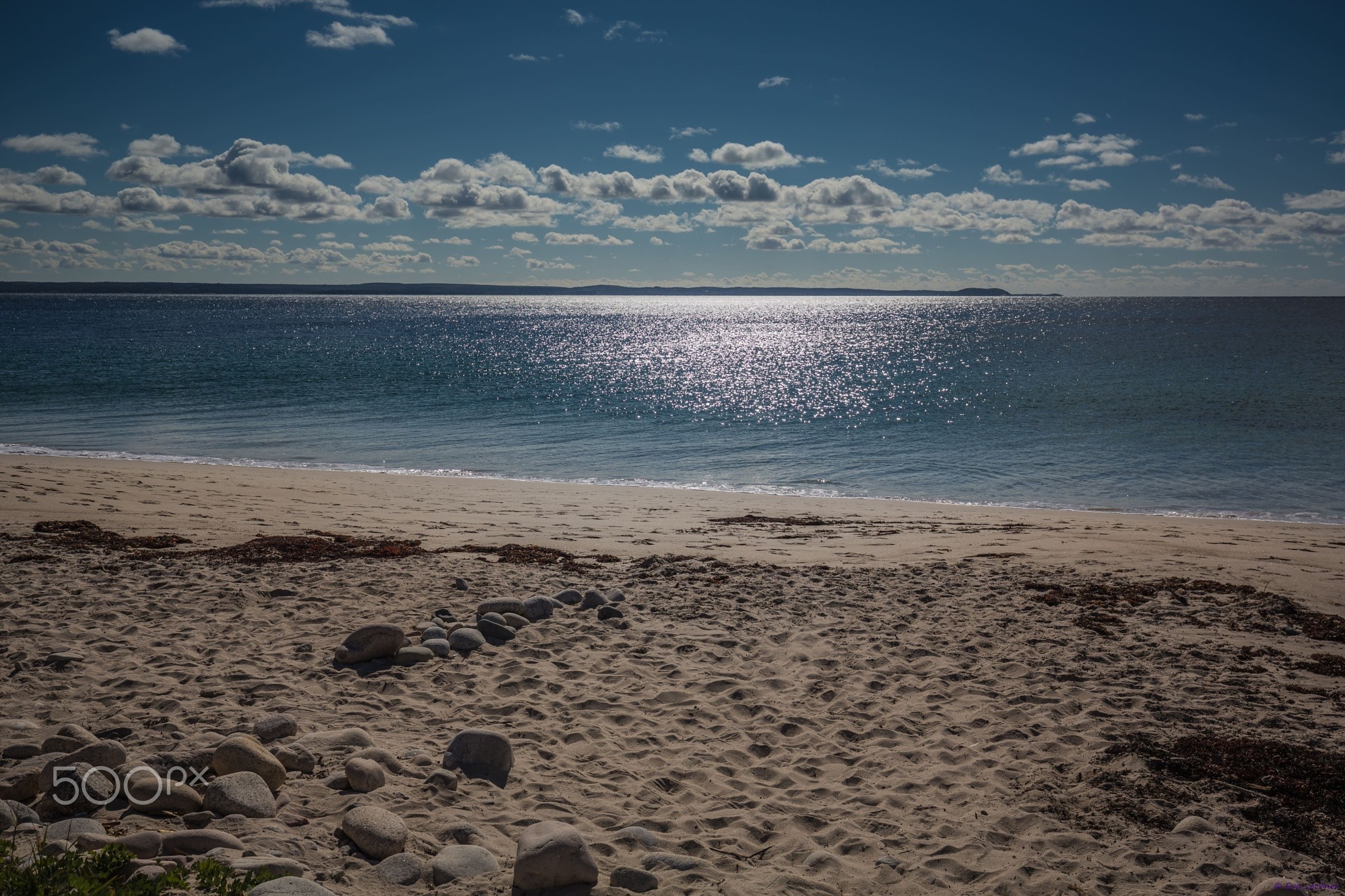 Sandy beach with ocean and clouds under a blue sky HD Wallpaper