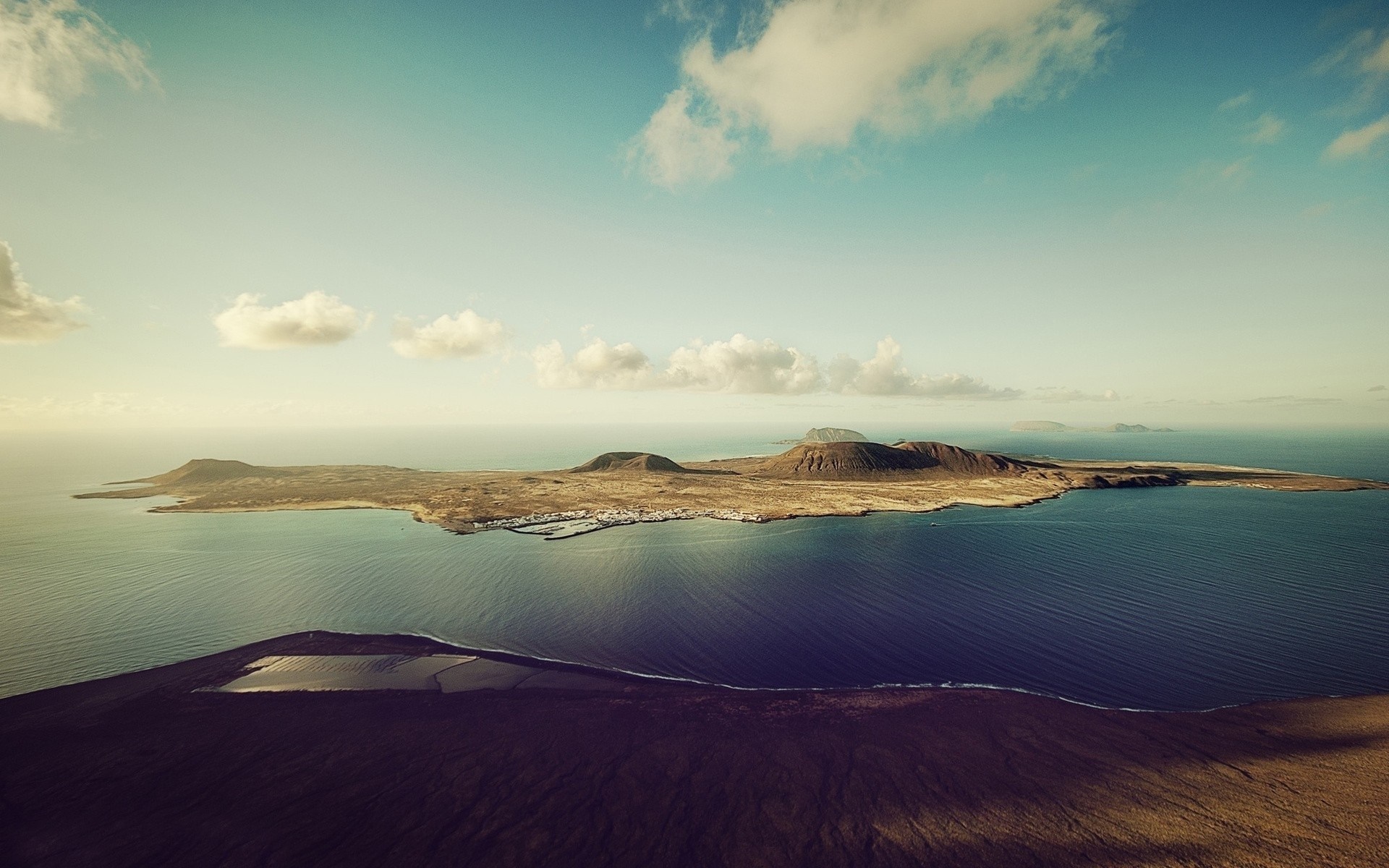 Island landscape with volcanic peaks and ocean HD Wallpaper