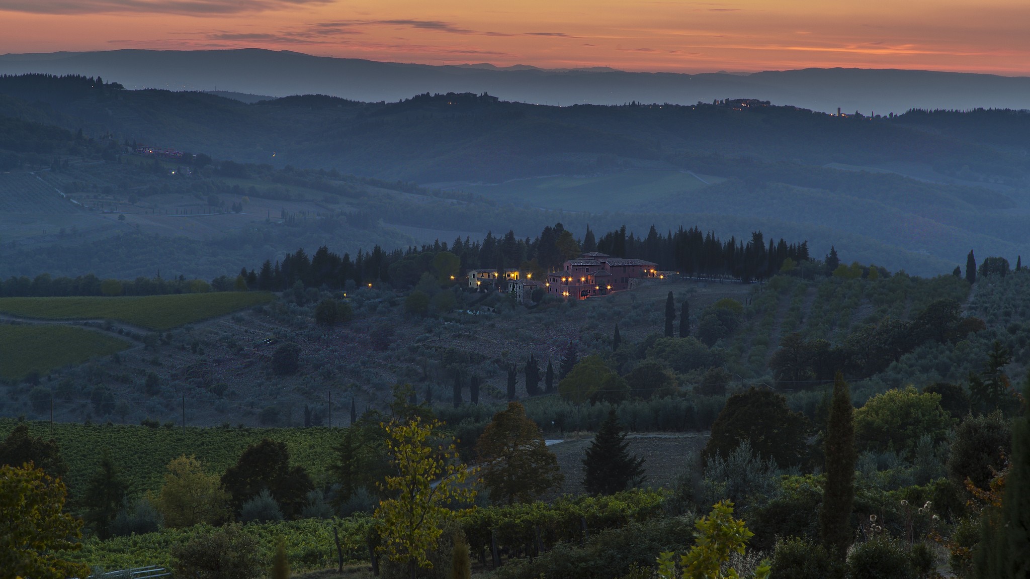Tuscan landscape at dusk with rolling hills and a villa HD Wallpaper
