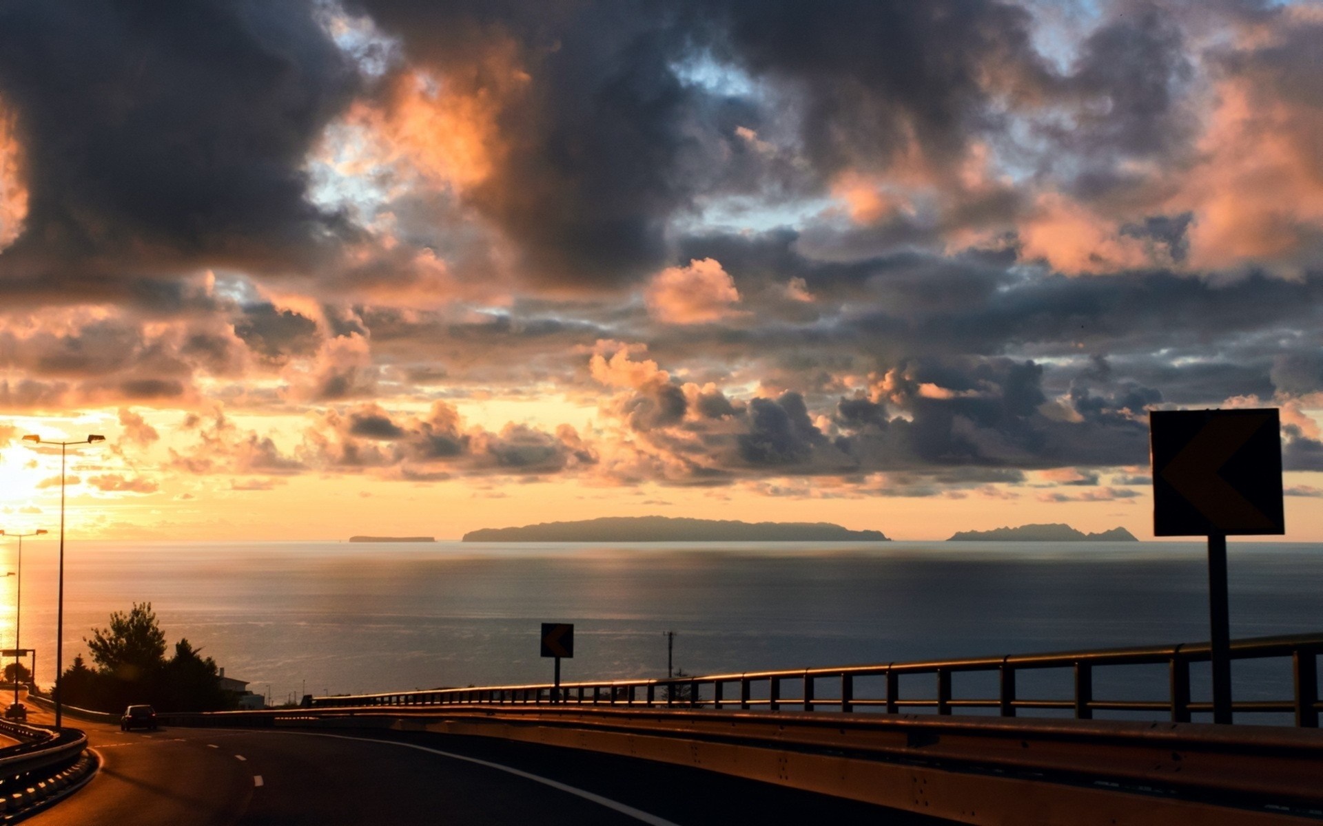 Sunset over the sea with islands and a highway HD Wallpaper