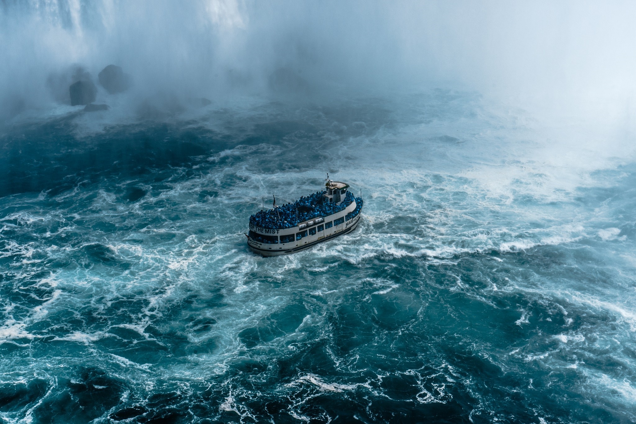 Tour boat navigating rough waters near Niagara Falls HD Wallpaper