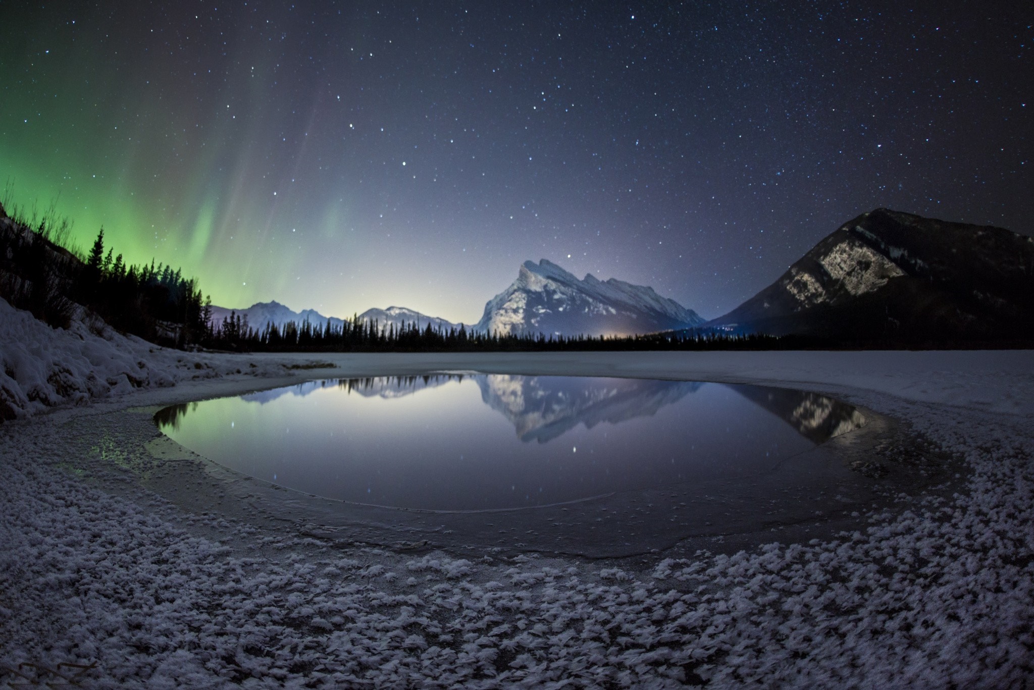 Aurora Borealis over frozen lake and mountains at night HD Wallpaper