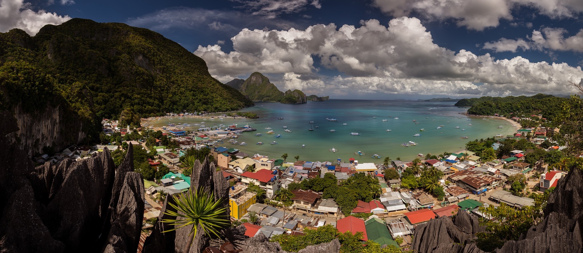 Panoramic view of a tropical bay with boats and a village HD Wallpaper