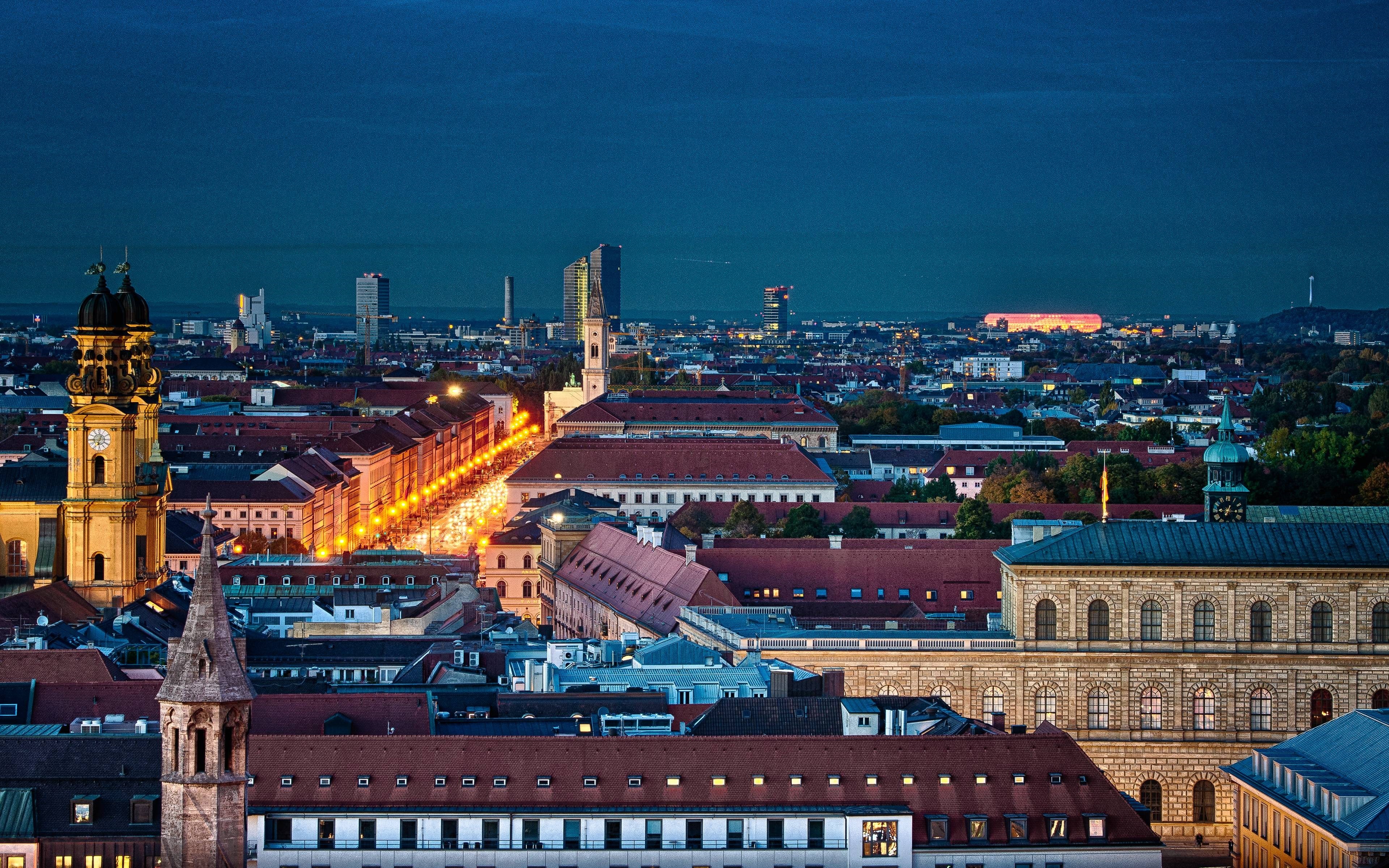 Munich cityscape at dusk with illuminated buildings and skyline HD Wallpaper