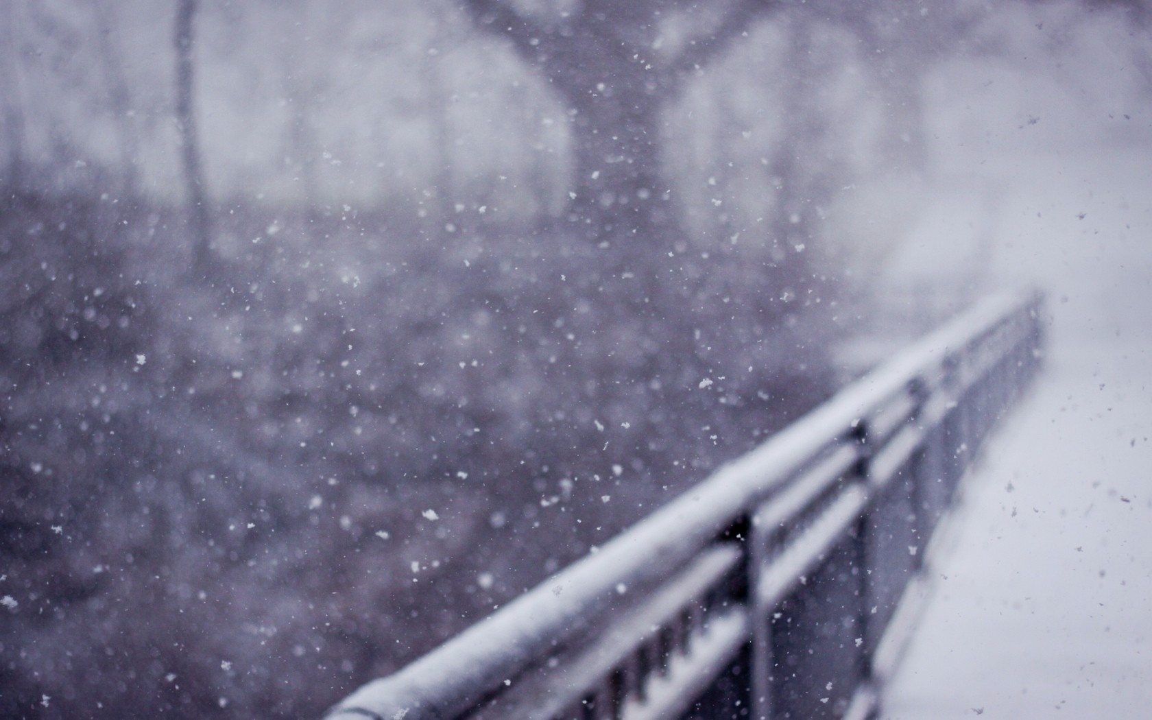 Snow falling on a bridge railing in winter HD Wallpaper