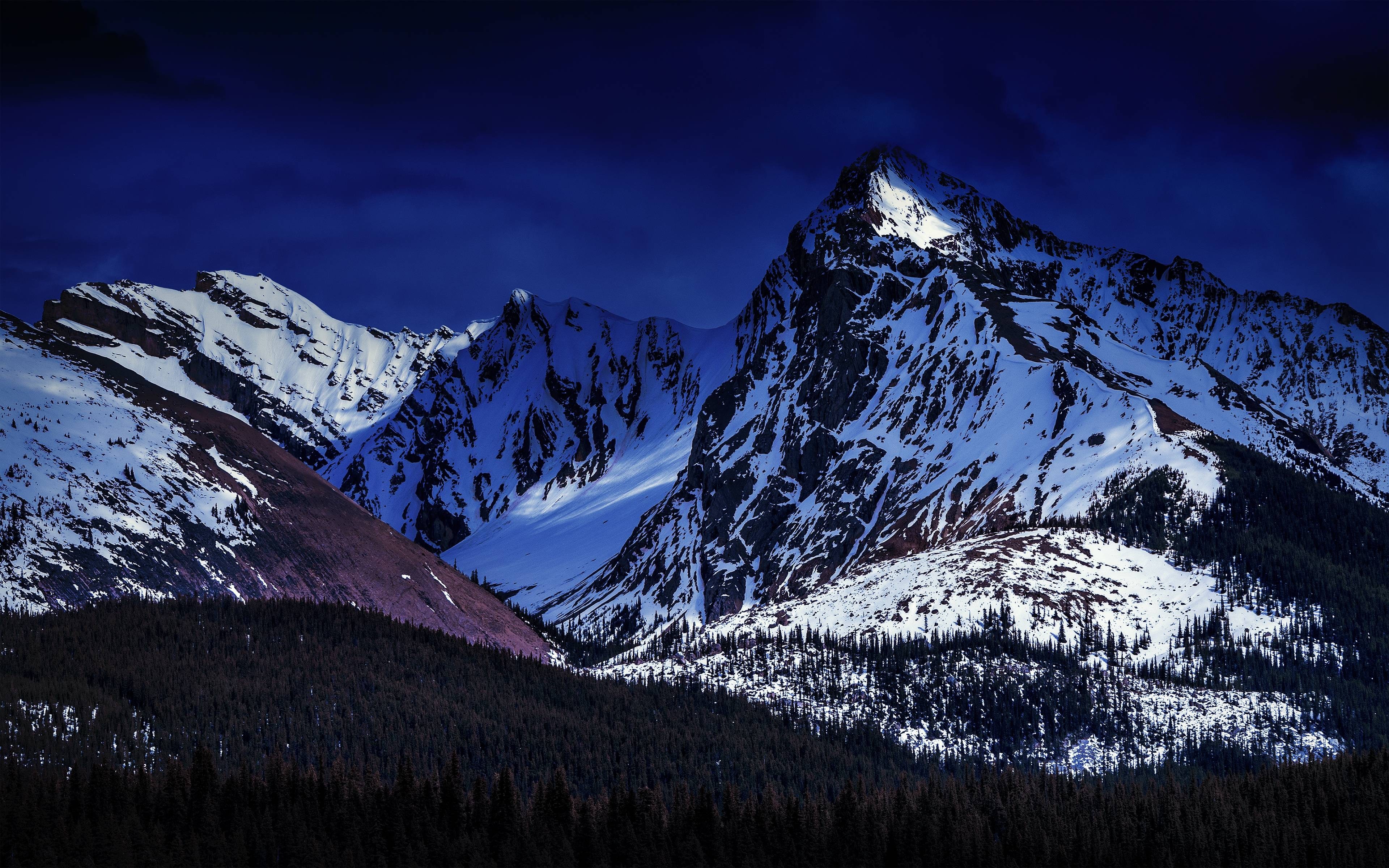 Snow-covered mountains under a dark blue sky HD Wallpaper