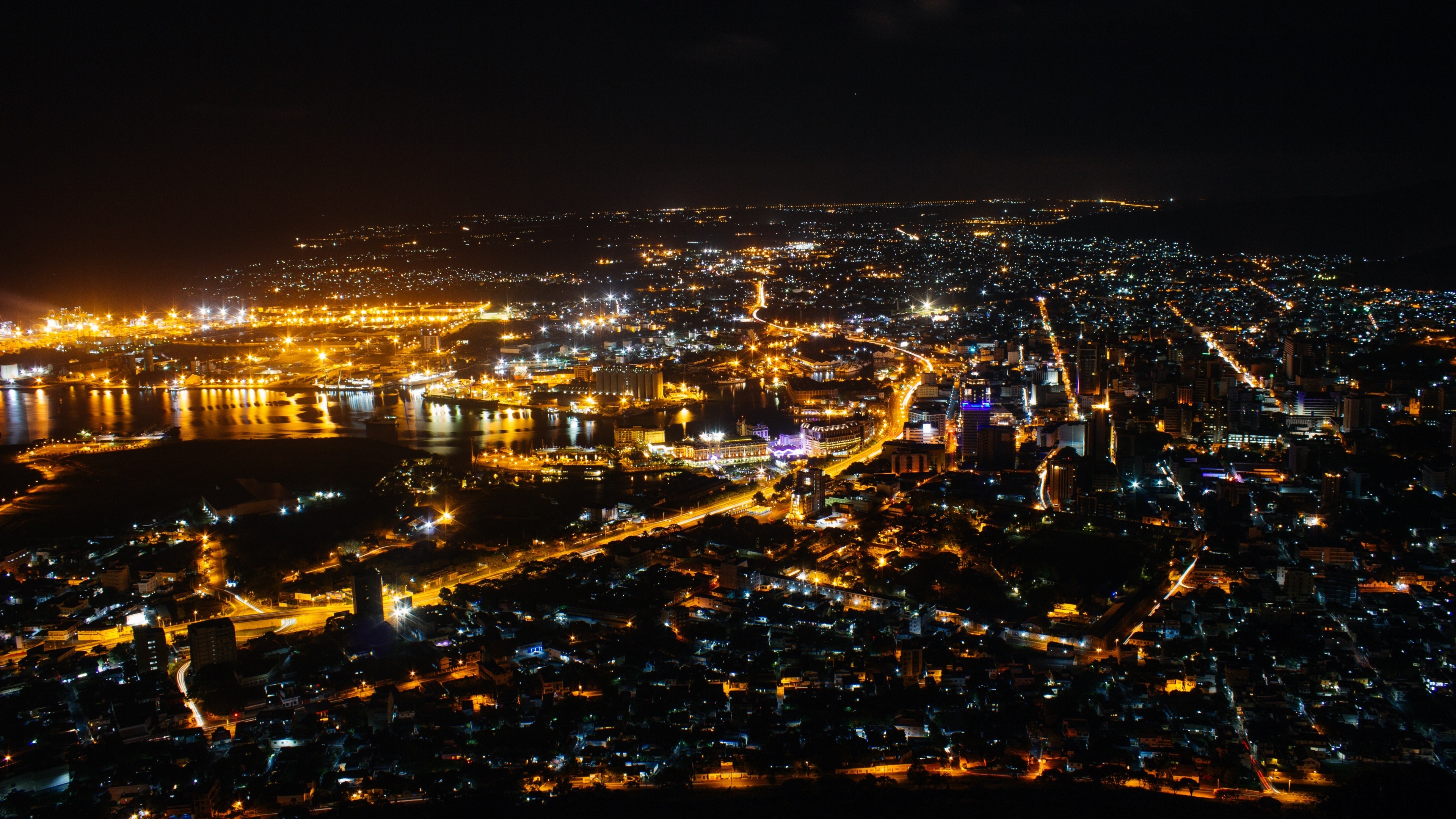 Aerial view of a city at night with glowing lights HD Wallpaper