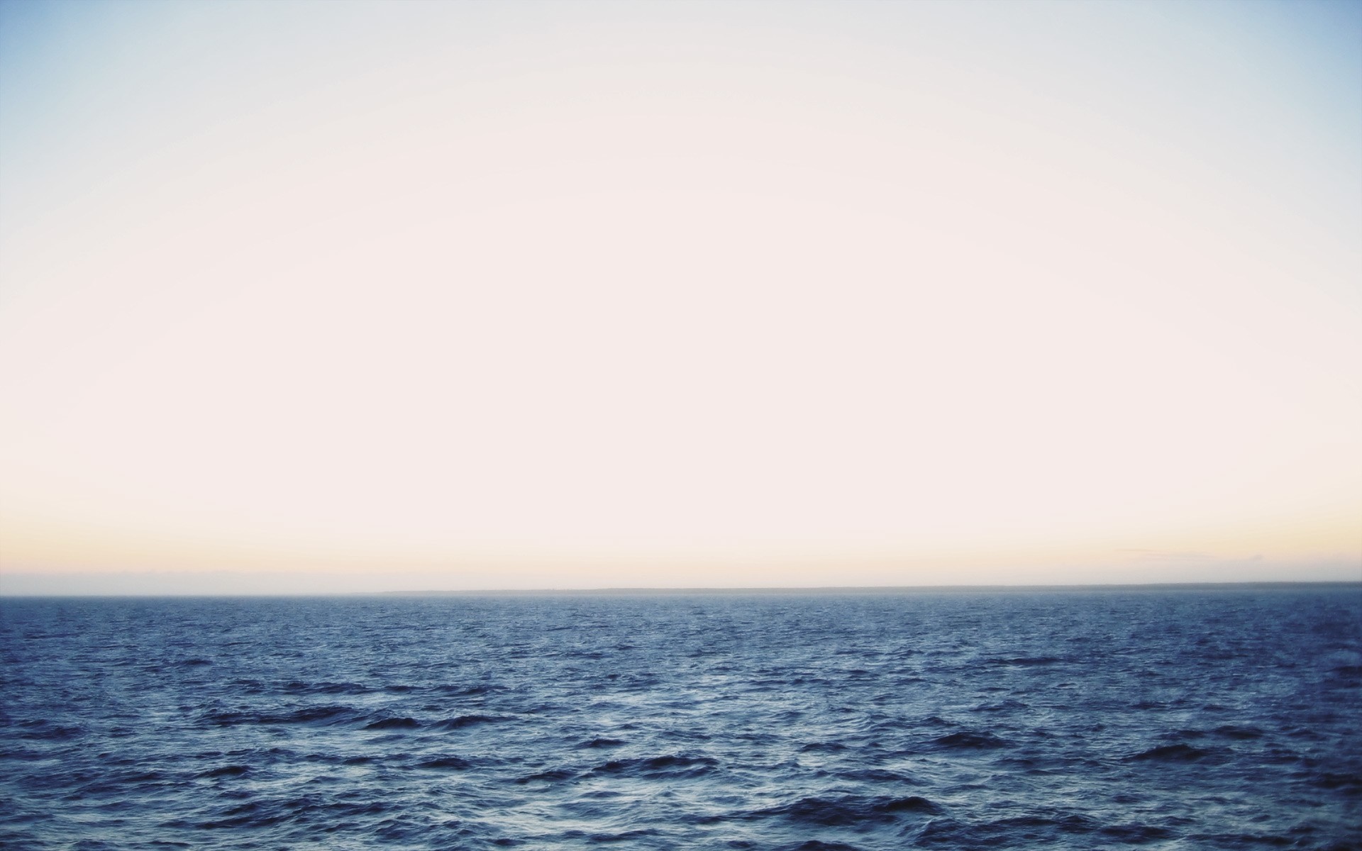 Ocean horizon at sunset with gentle waves HD Wallpaper
