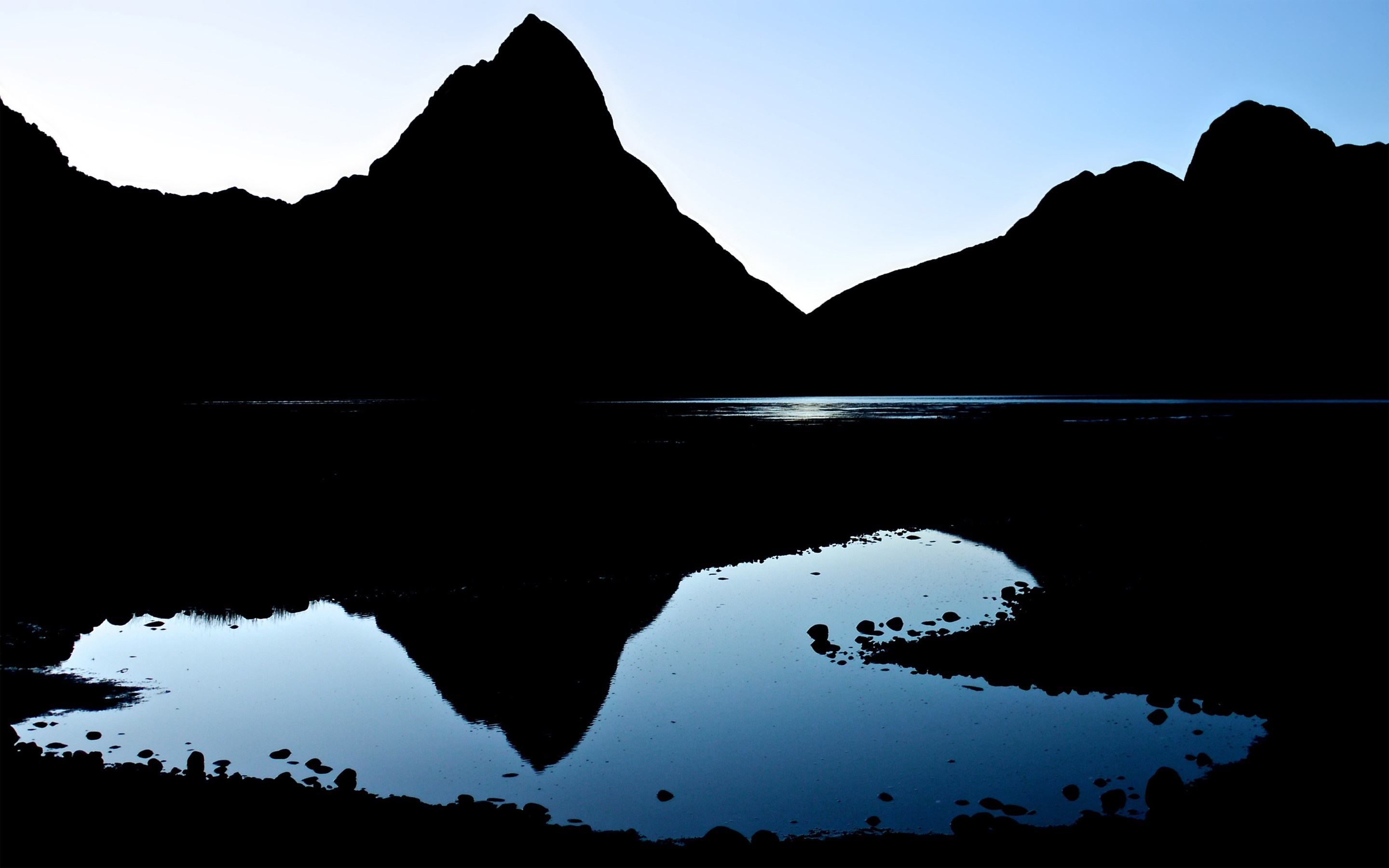 Silhouette of mountains reflected in a lake at dawn HD Wallpaper