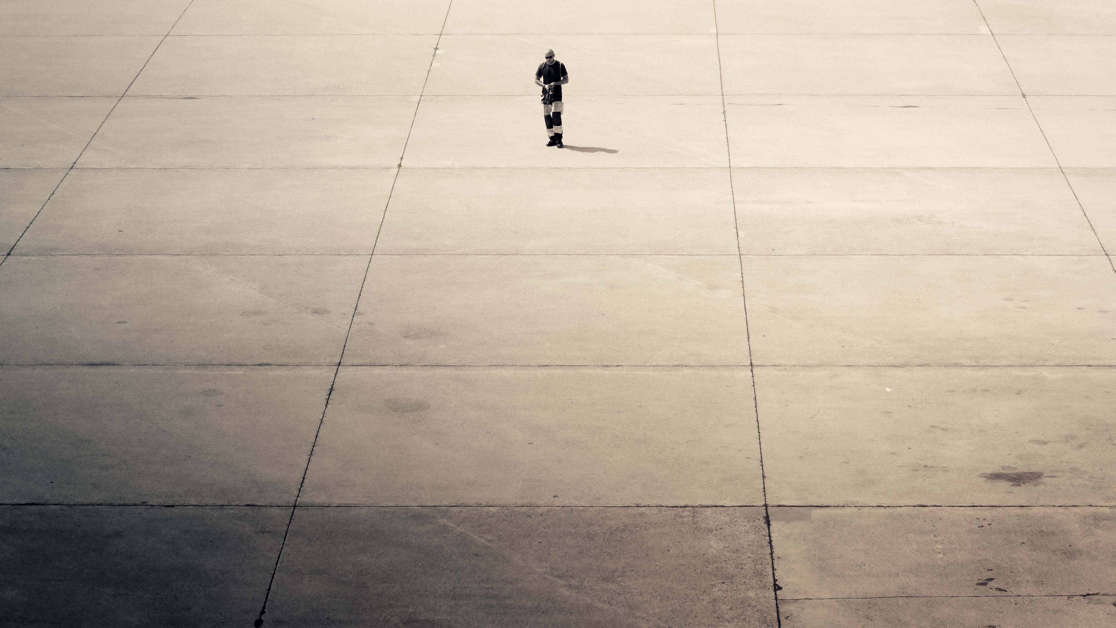 Man standing on a concrete surface with lines HD Wallpaper