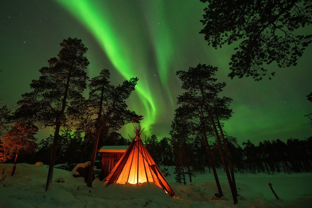 Tipi lit by fire under Aurora Borealis HD Wallpaper