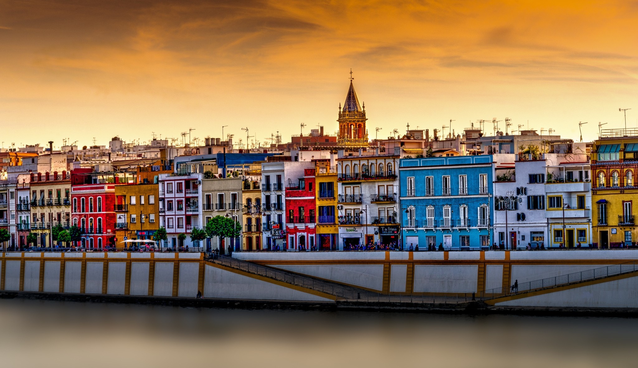 Colorful buildings along a river at sunset HD Wallpaper
