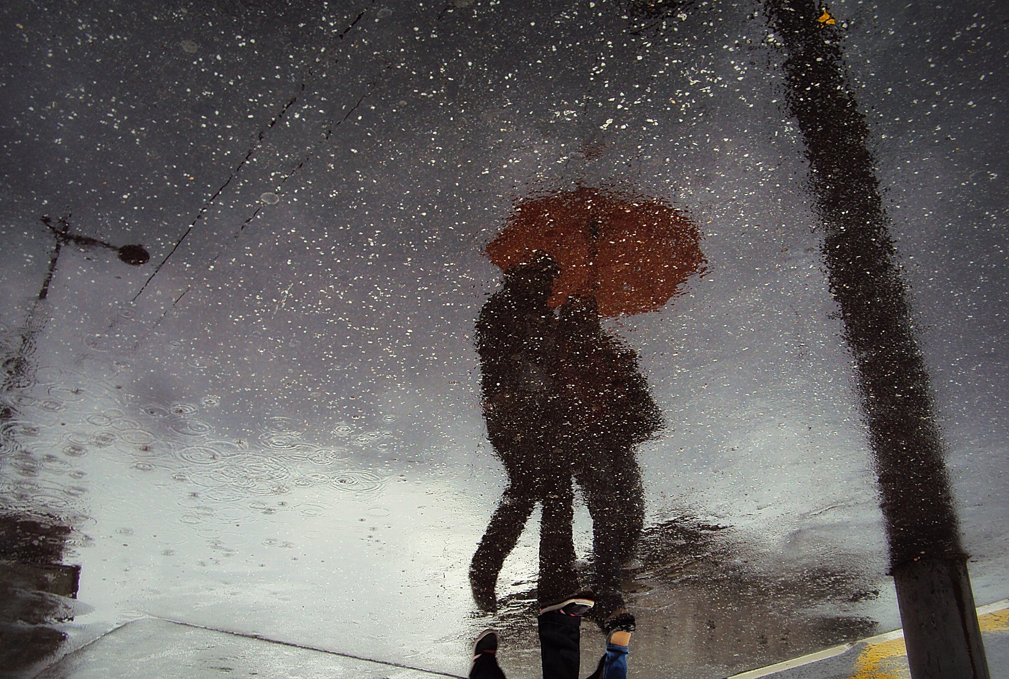 Reflection of two people with umbrella in rain HD Wallpaper