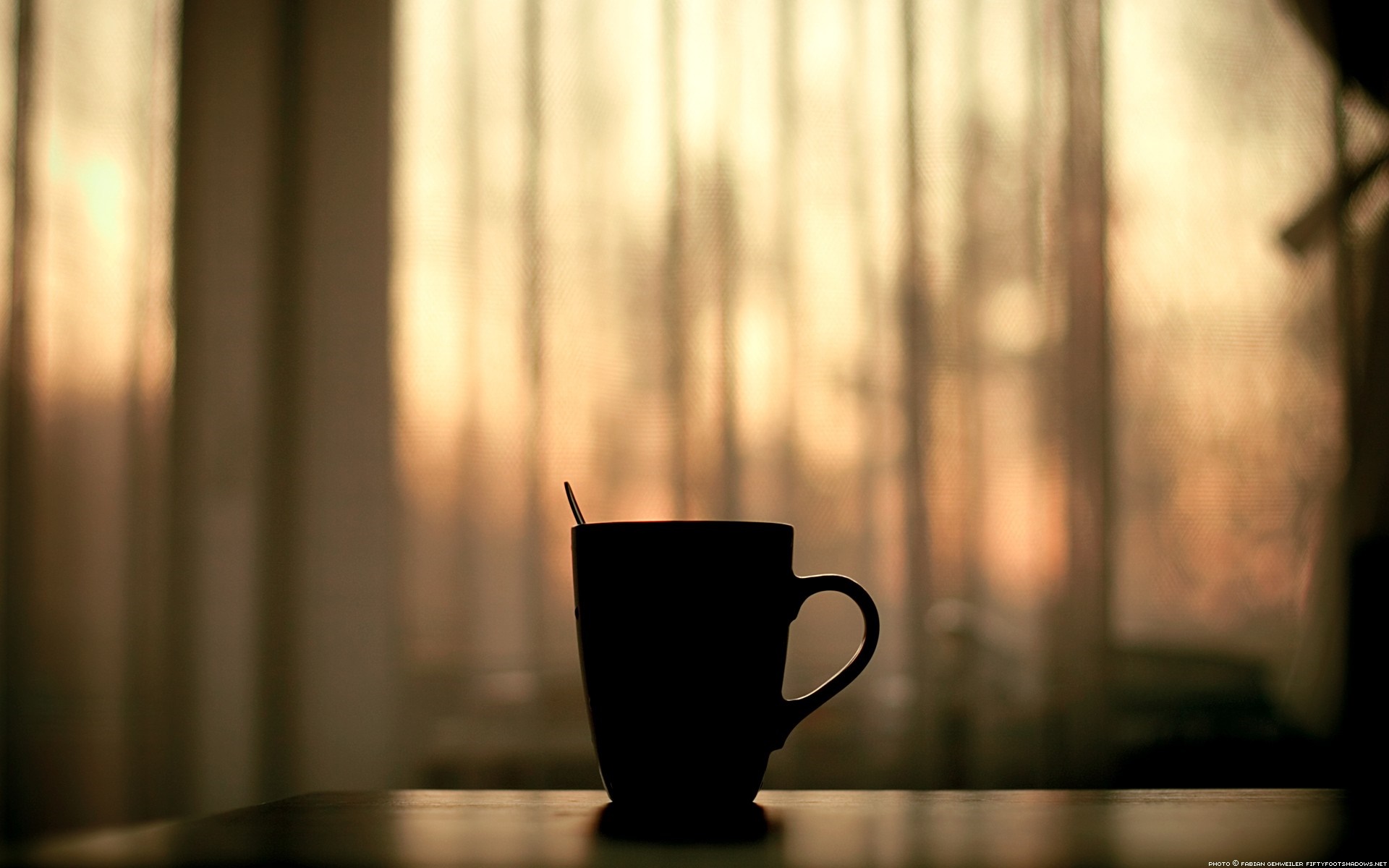 Silhouette of a mug with a spoon on a table HD Wallpaper