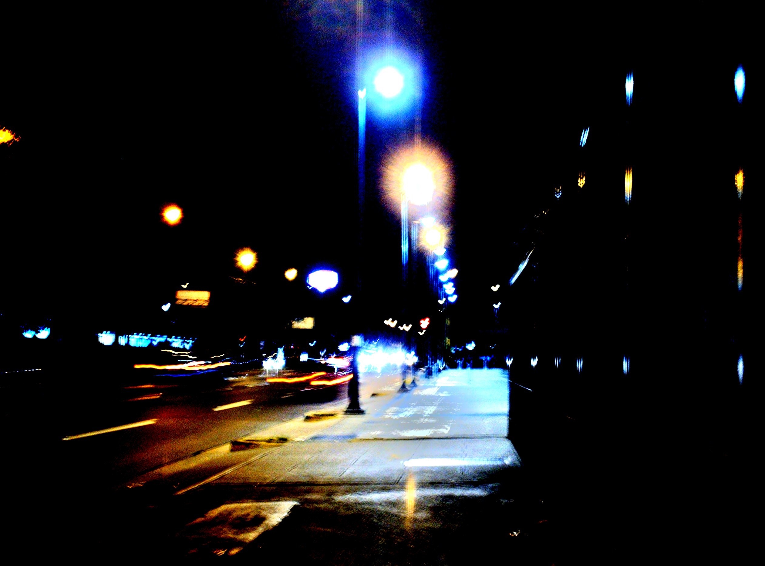 City street at night with blurred lights HD Wallpaper