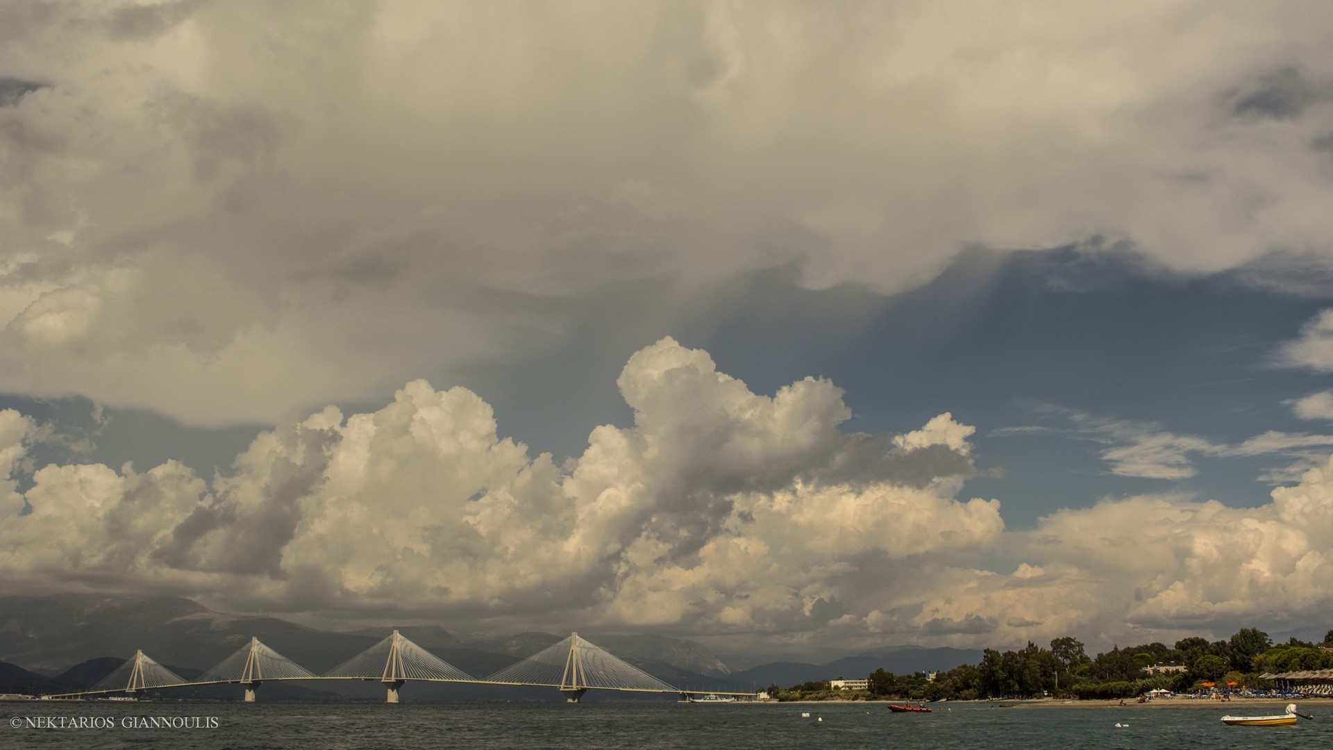 Cable-stayed bridge over the sea under dramatic clouds HD Wallpaper