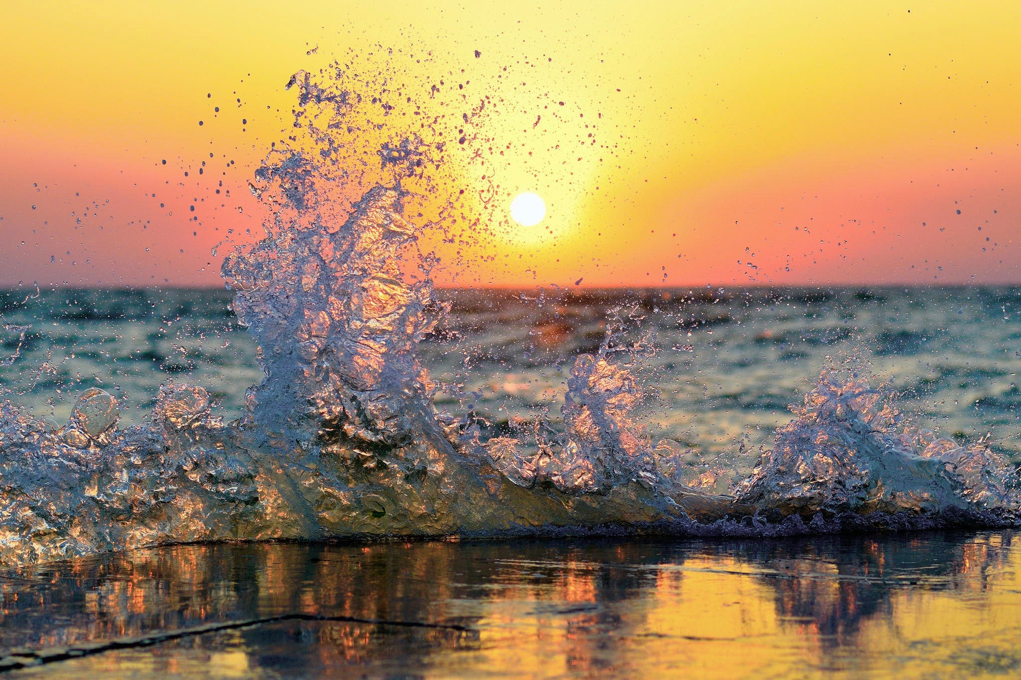 Wave crashing at sunset over the ocean HD Wallpaper
