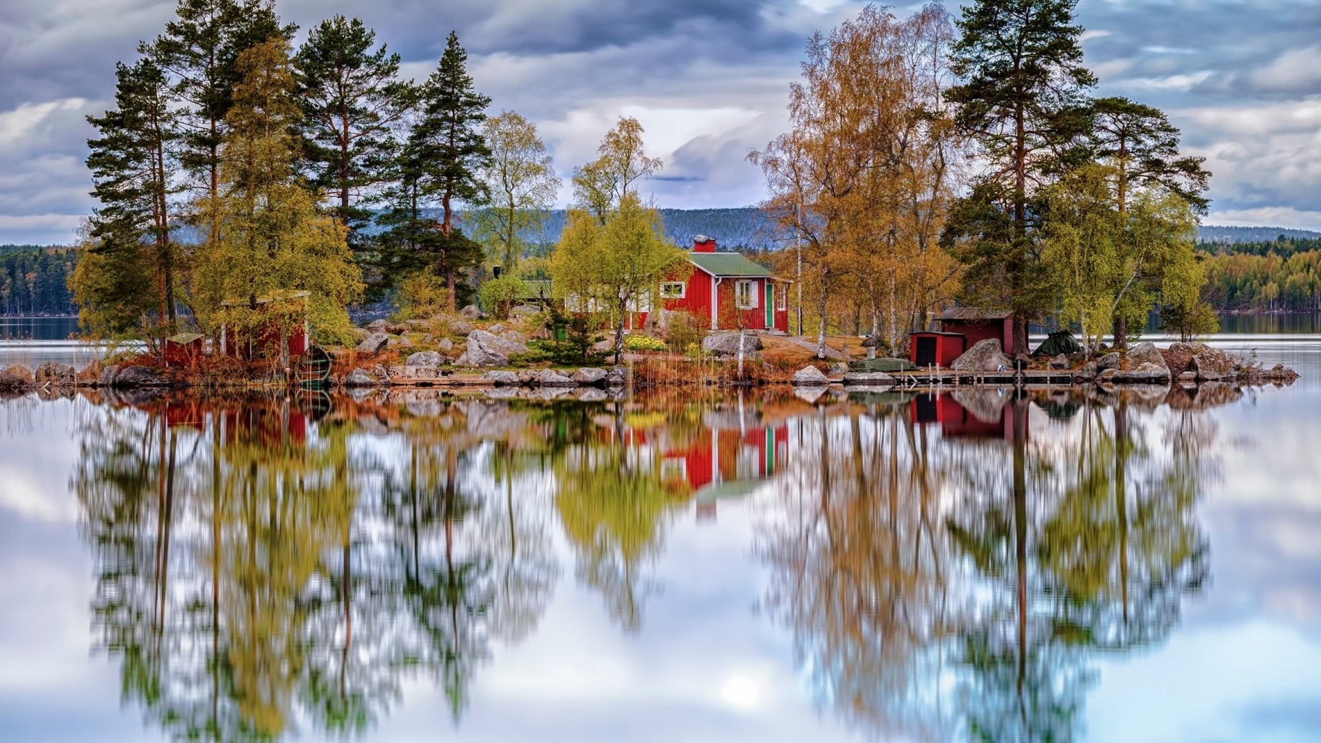 Red cabin on an island with autumn trees reflected in the lake HD Wallpaper