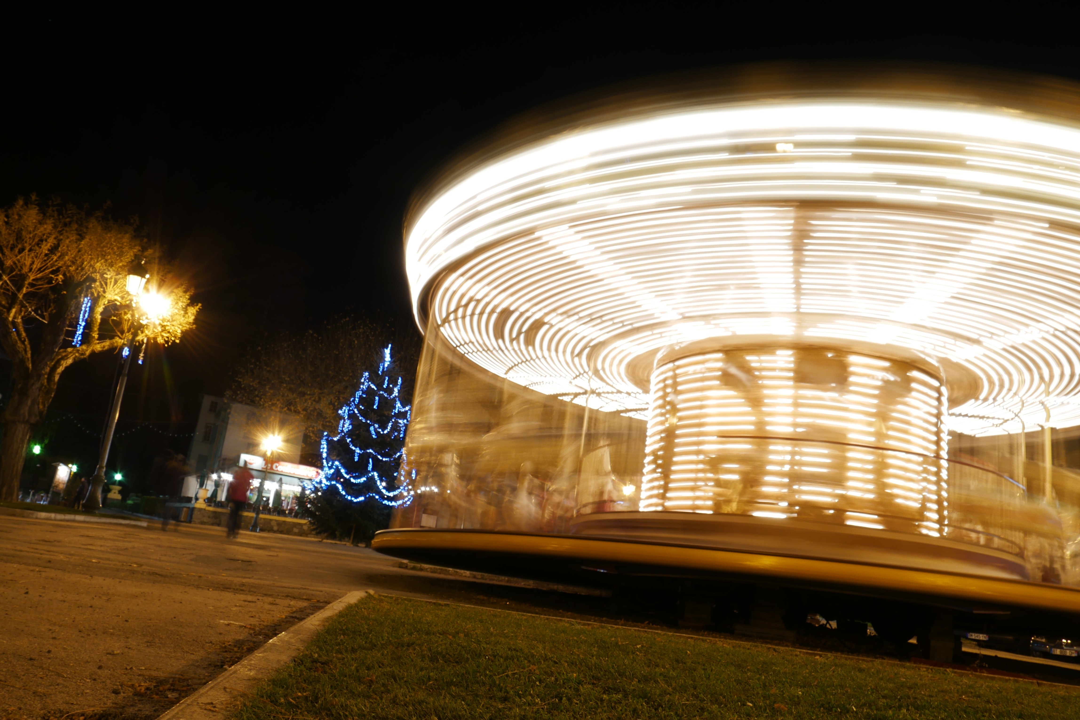 Carousel with Christmas tree and street lights at night HD Wallpaper