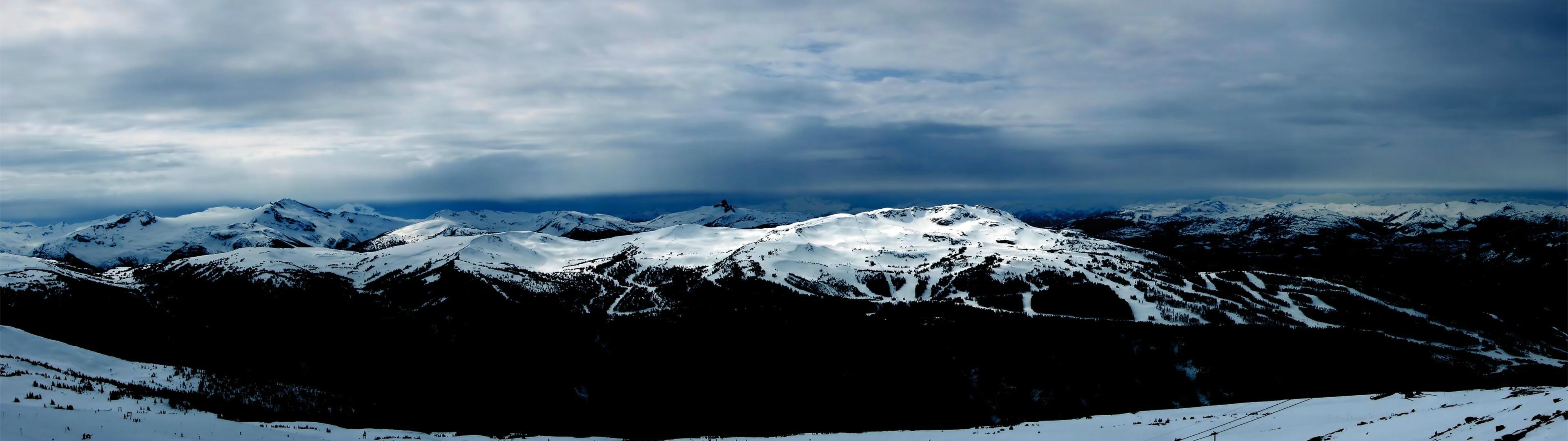 Snowy mountain range under a cloudy sky HD Wallpaper