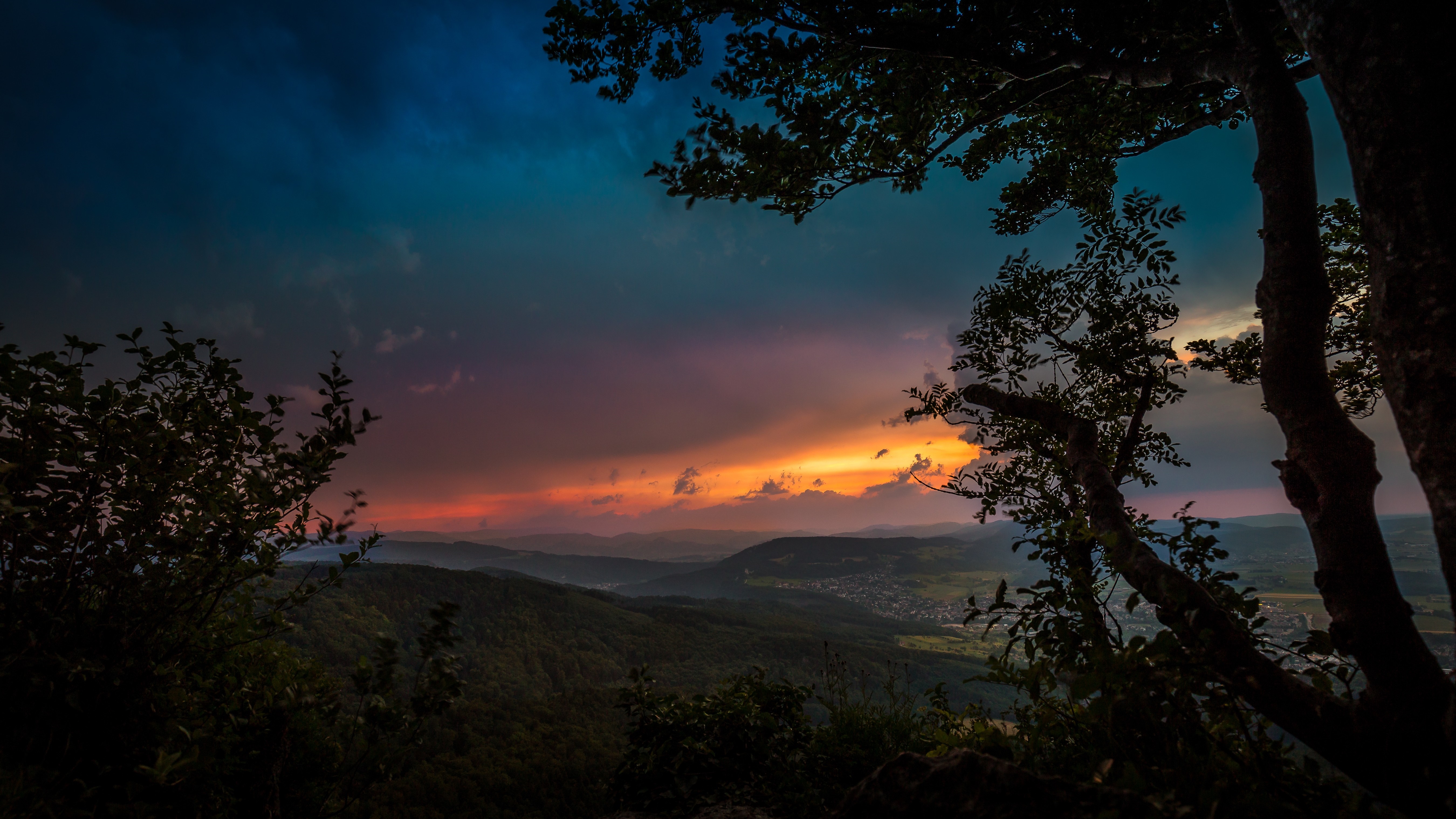 Sunset over hills with trees in foreground HD Wallpaper