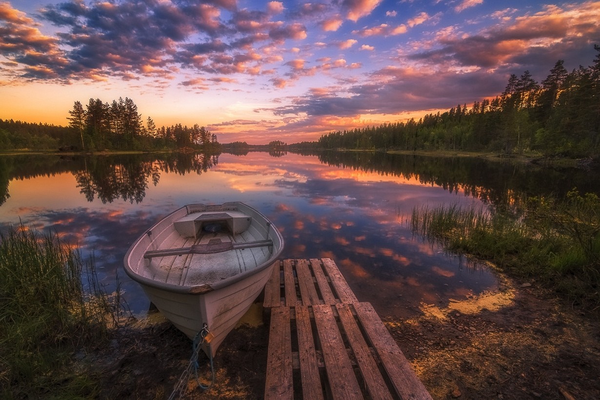 Boat docked on a lake at sunset with colorful clouds HD Wallpaper