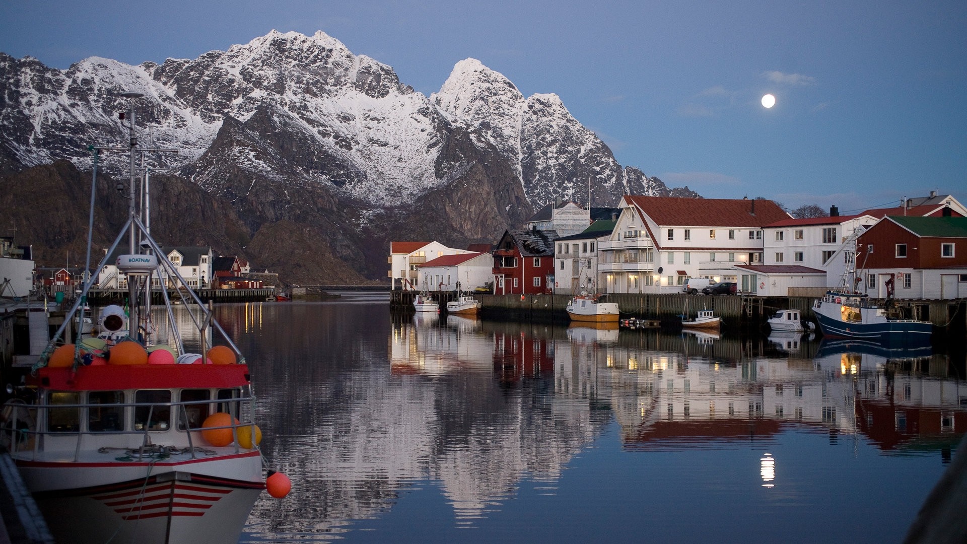 Fishing boats in a Norwegian town with snowy mountains and moon HD Wallpaper