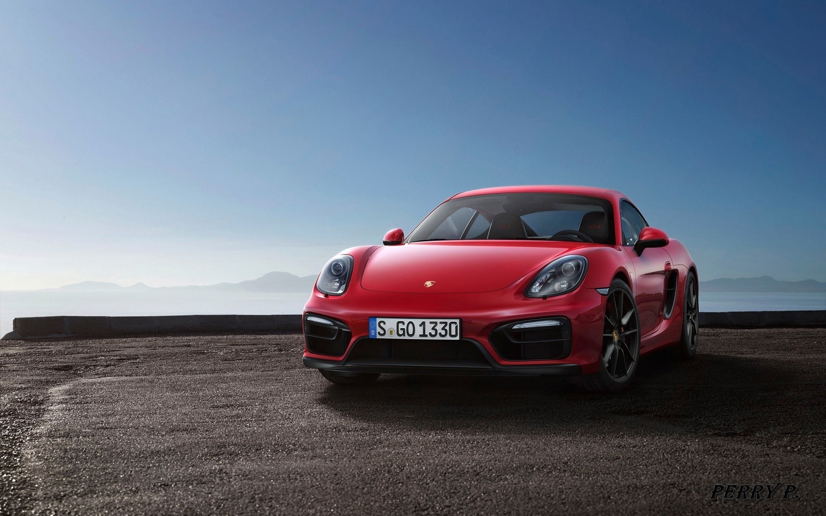 Red Porsche Cayman S parked by the sea HD Wallpaper