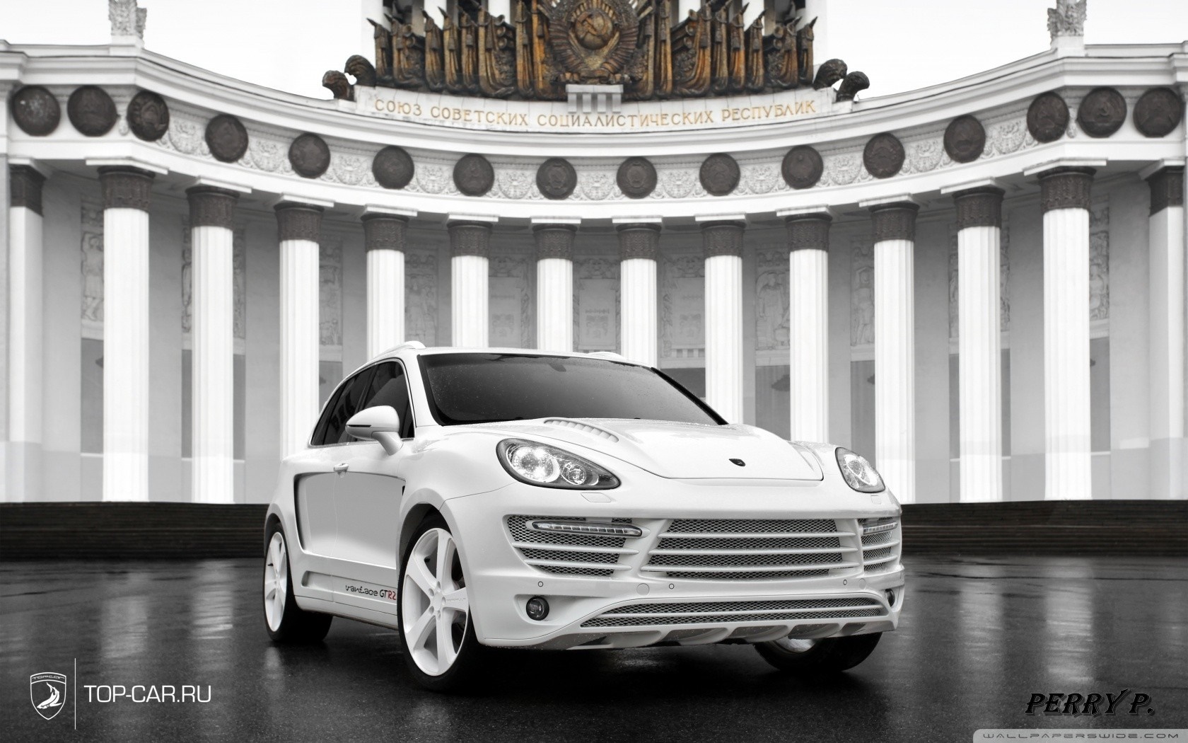 White Porsche Cayenne GT3 in front of Soviet-era building HD Wallpaper