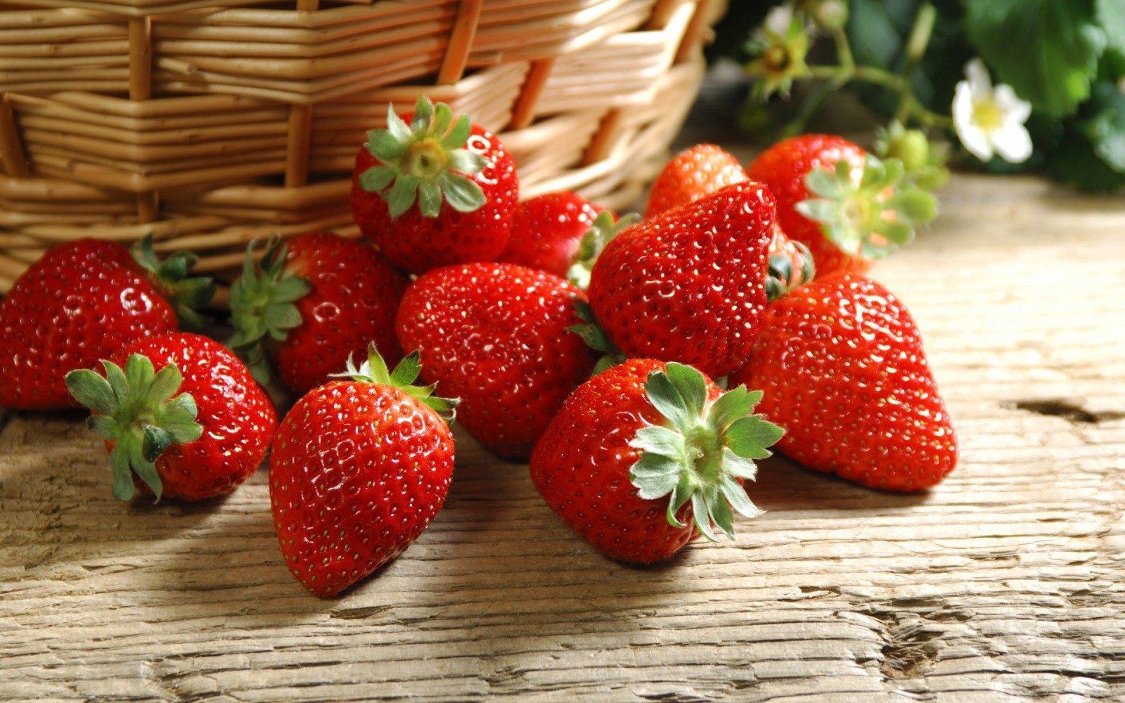 Strawberries in a basket on a wooden table HD Wallpaper