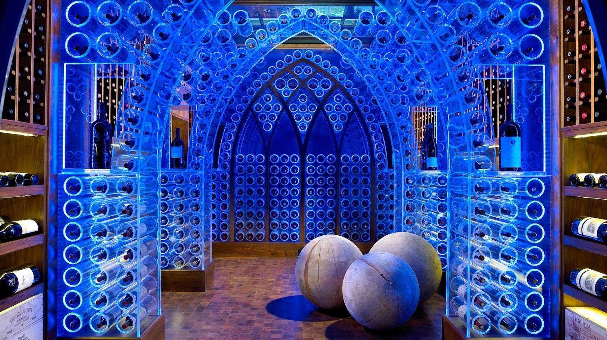 Modern wine cellar with blue lighting and spherical decor HD Wallpaper