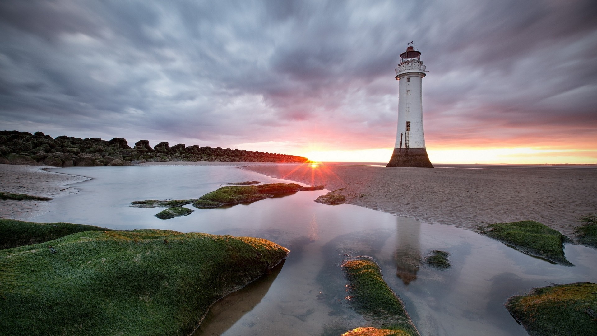 Lighthouse on a beach at sunset with reflection HD Wallpaper