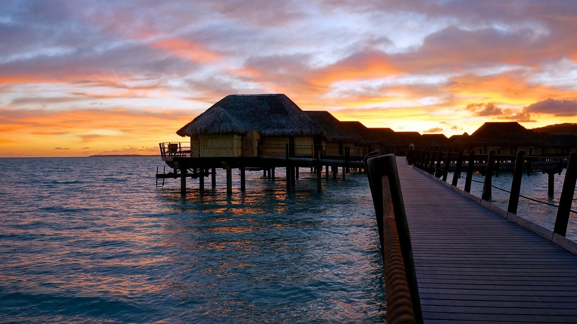 Overwater bungalows at sunset with a wooden pier HD Wallpaper