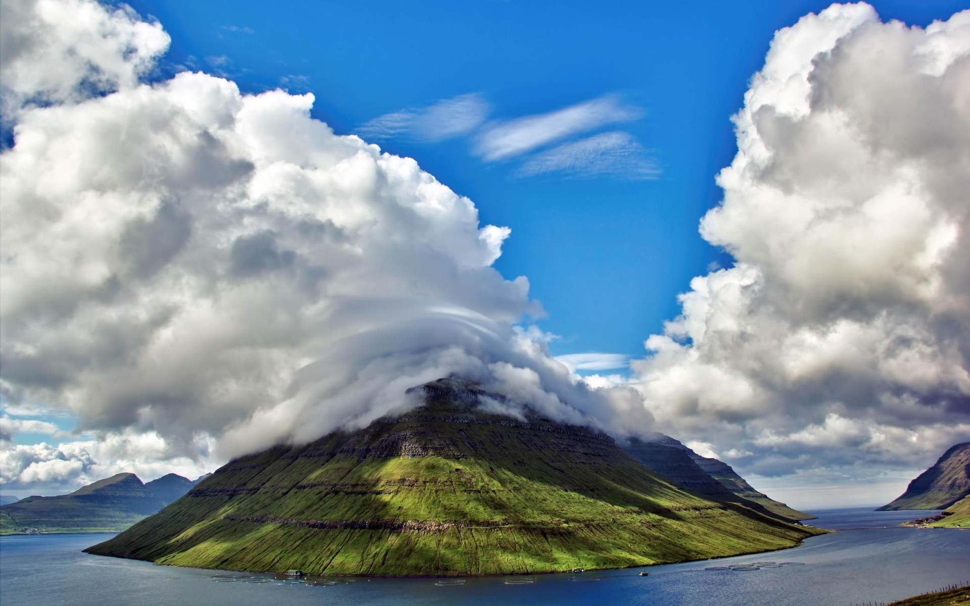 Mountain island covered in clouds over the sea HD Wallpaper