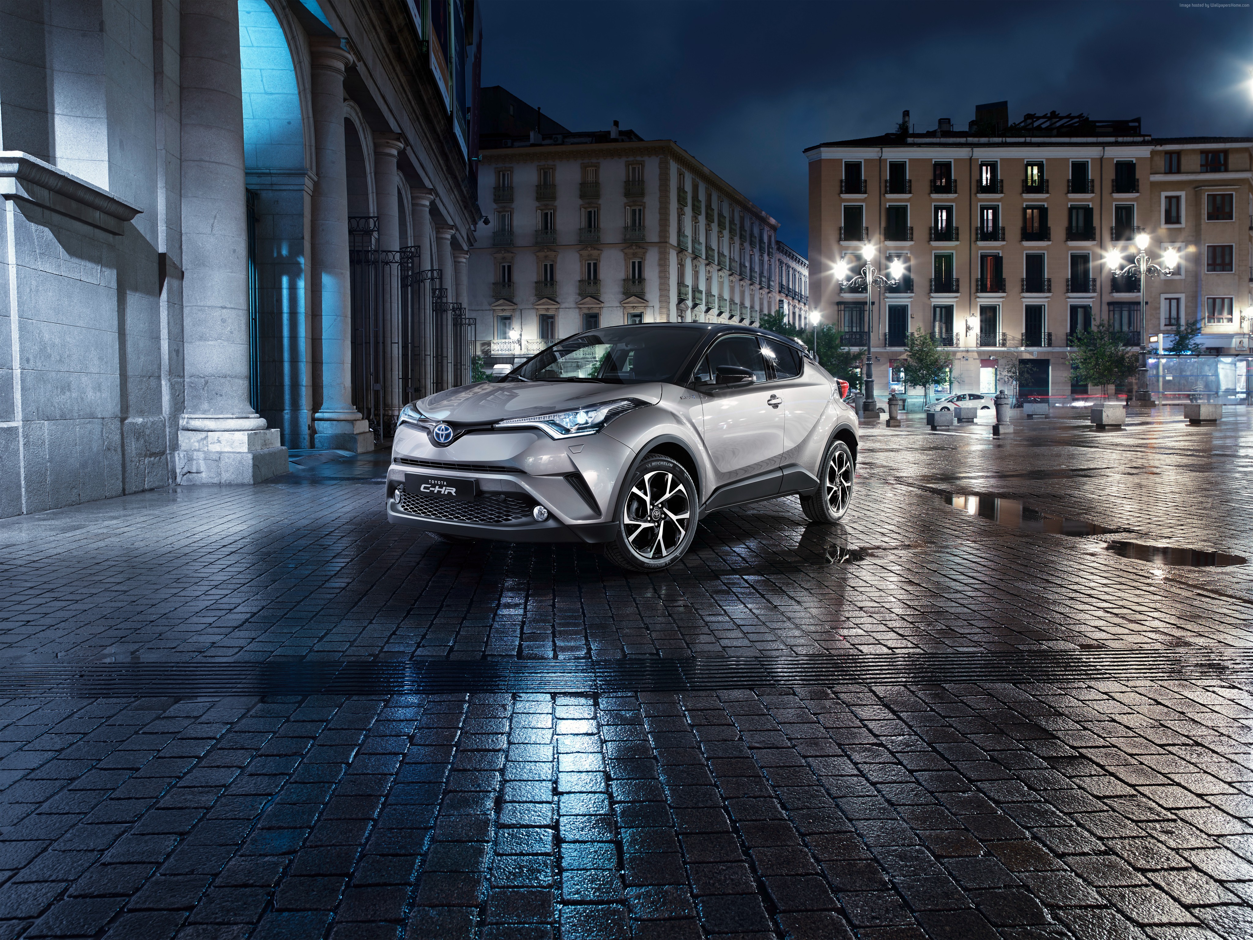 Toyota C-HR crossover parked on wet cobblestone street at night HD Wallpaper