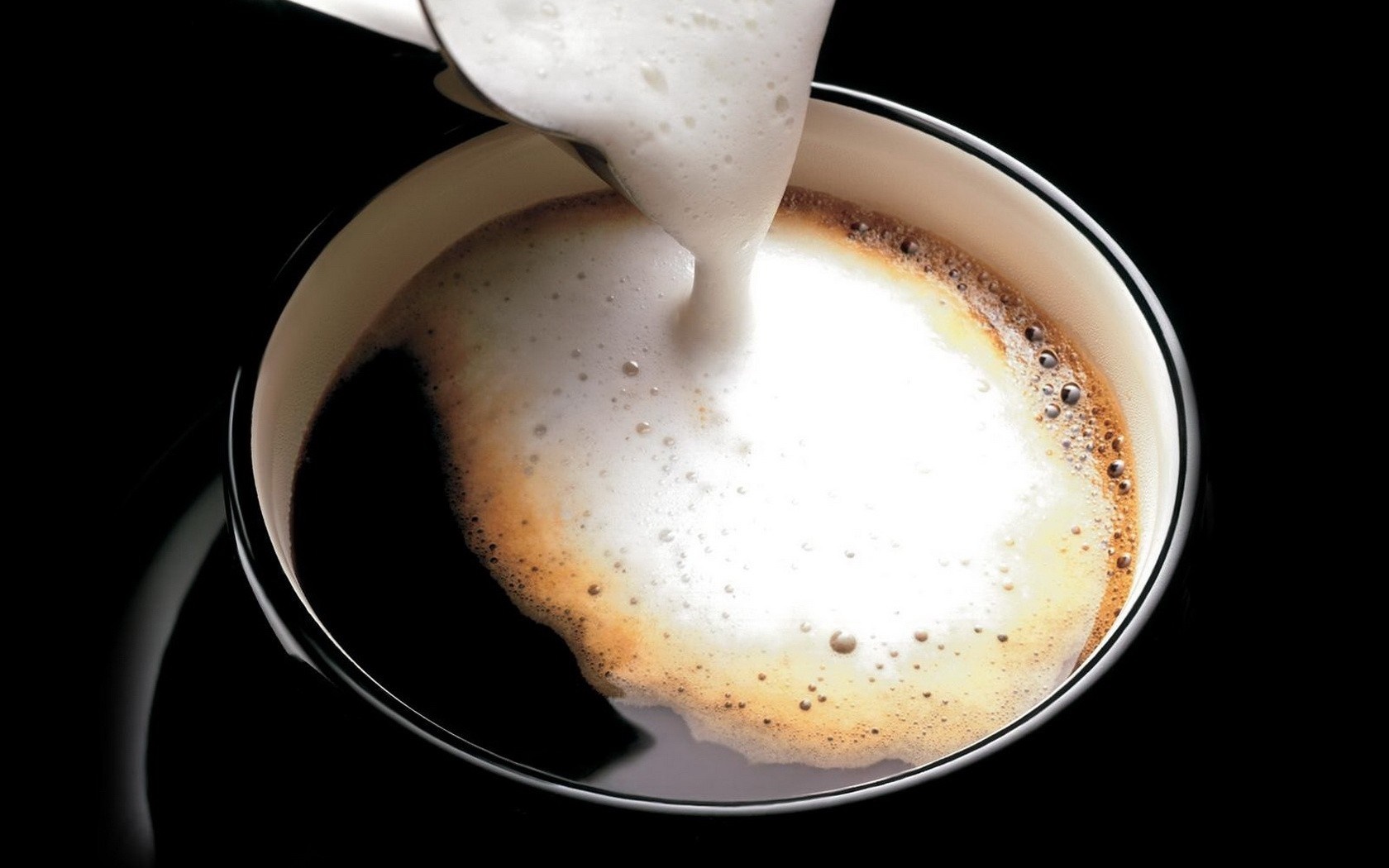 Foam being poured into a cup of coffee HD Wallpaper